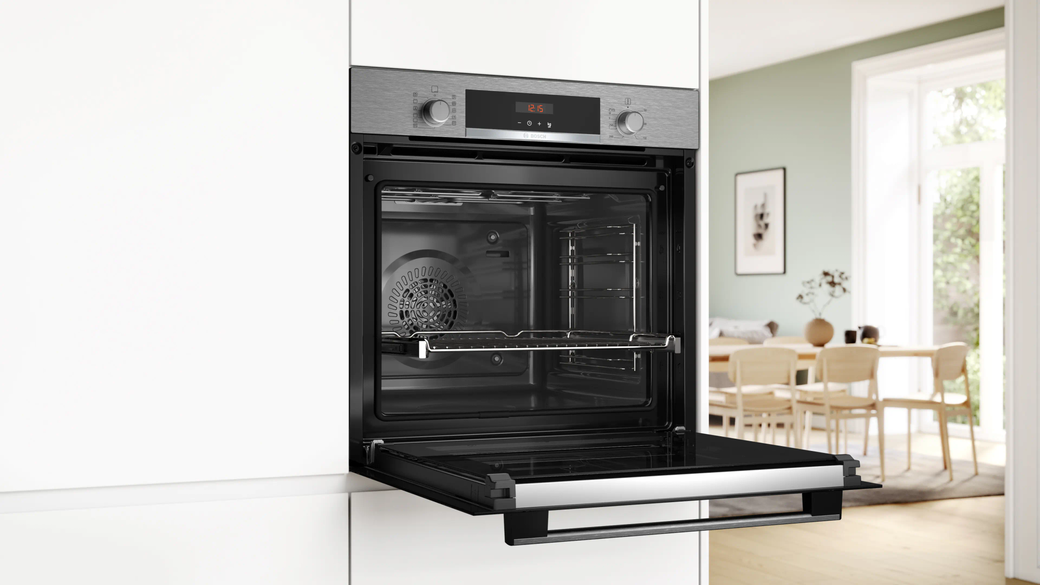 Un forno aperto con frontale in acciaio inossidabile. L'interno ha griglie e una ventola. La cucina ha mobili bianchi e una zona pranzo.