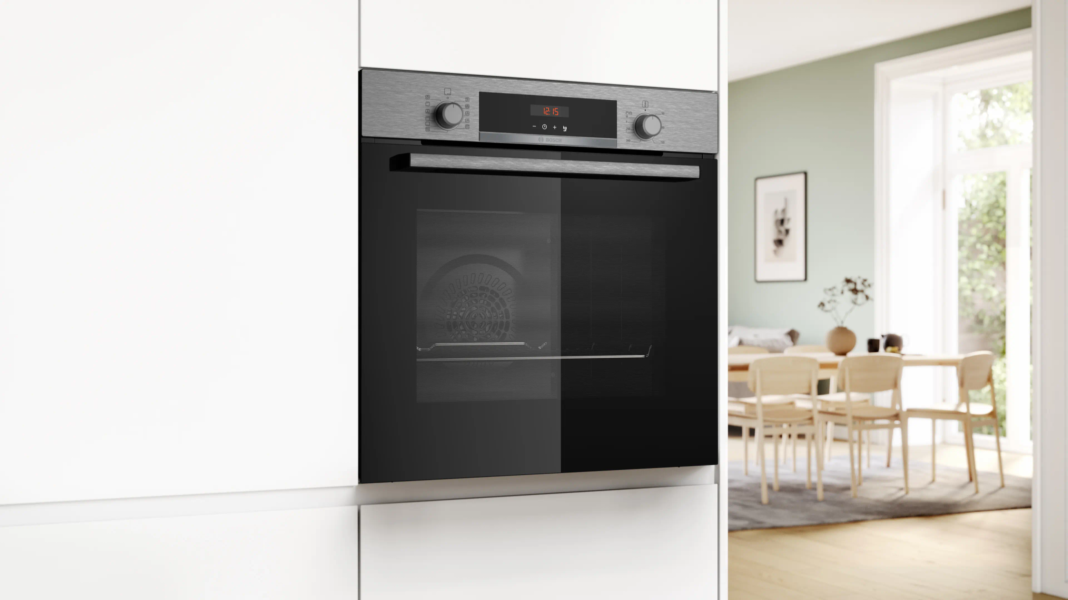 Un forno a incasso con porta in vetro nero in una cucina bianca. Una sala da pranzo con tavolo e sedie è visibile.