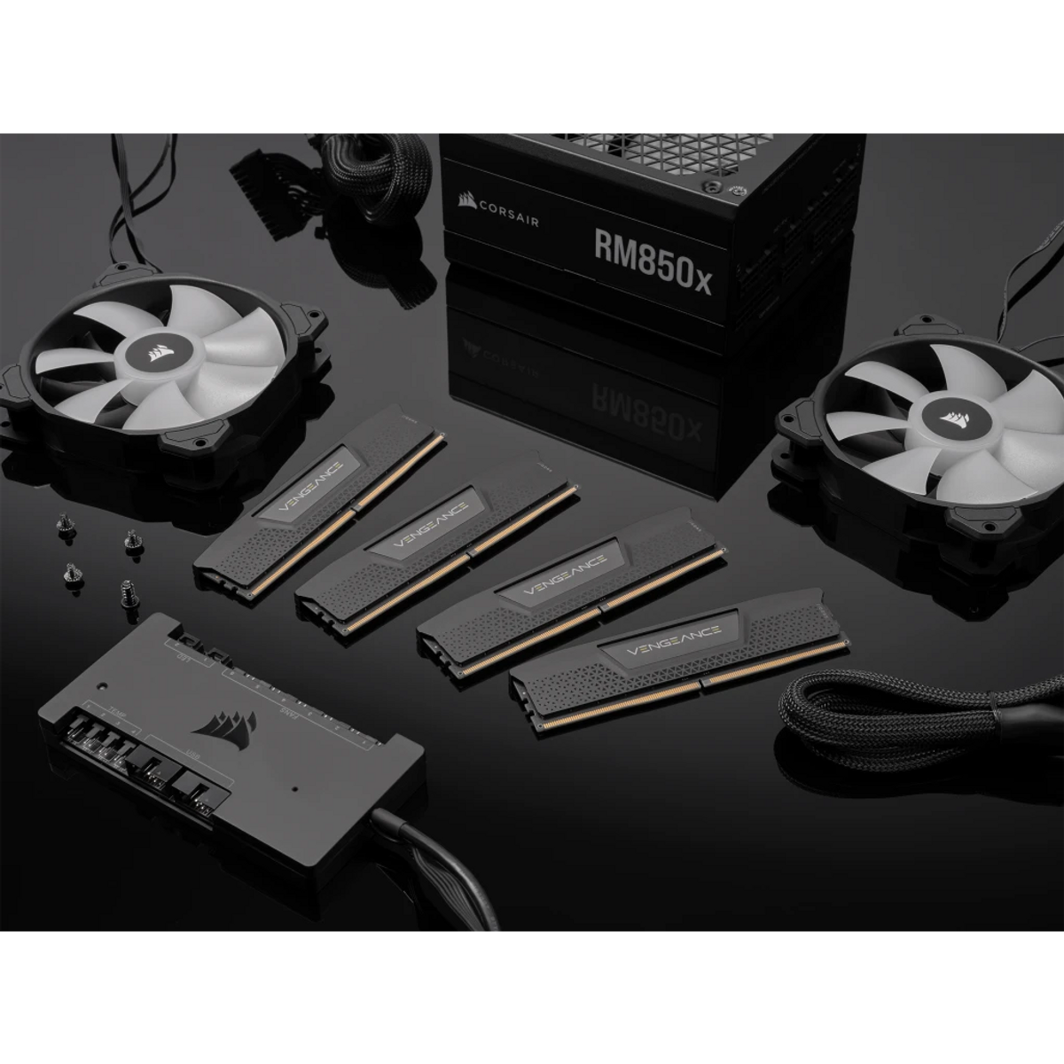 Czarny zestaw komponentów PC z zasilaczem, pamięcią RAM, wentylatorami i kontrolerem. Scena znajduje się na odblaskowej czarnej powierzchni.