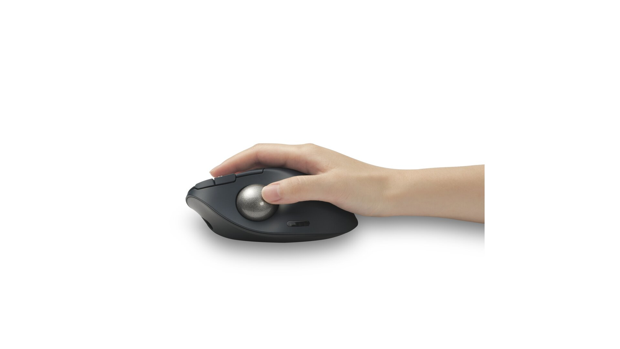 A hand holds a dark gray trackball mouse. The trackball is silver. The background is white.