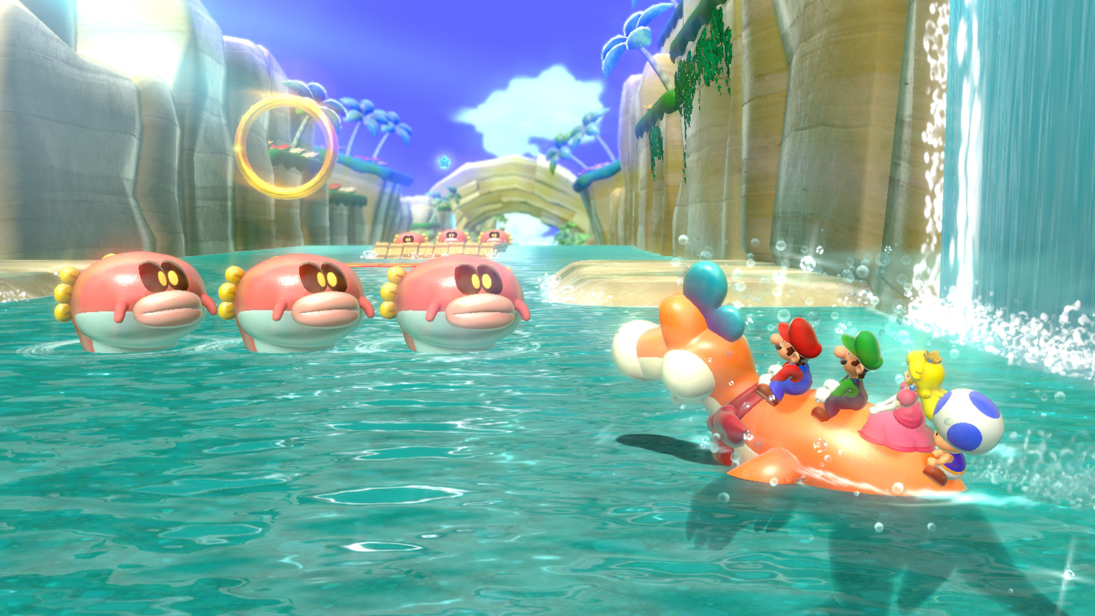 Mario, Luigi, Peach e Toad cavalcano una creatura in acqua. Pesci palla rosa nuotano nelle vicinanze. Un anello e una cascata sullo sfondo.