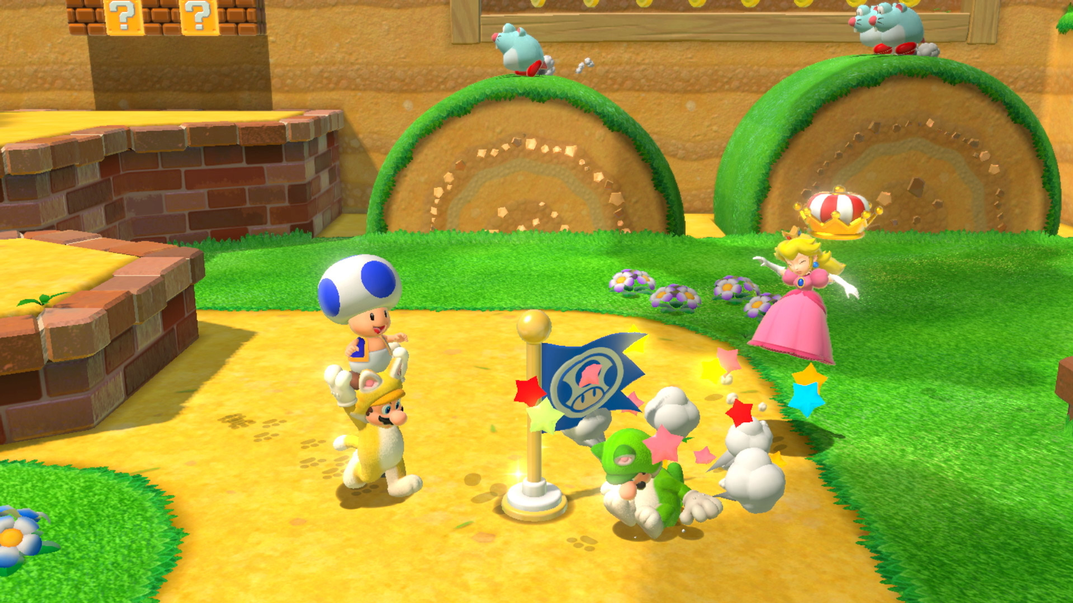 I personaggi di Mario Toad, Luigi e Peach in una scena colorata. Sono vicino a una bandiera, circondati da nemici e stelle. Due creature sono su colline verdi.
