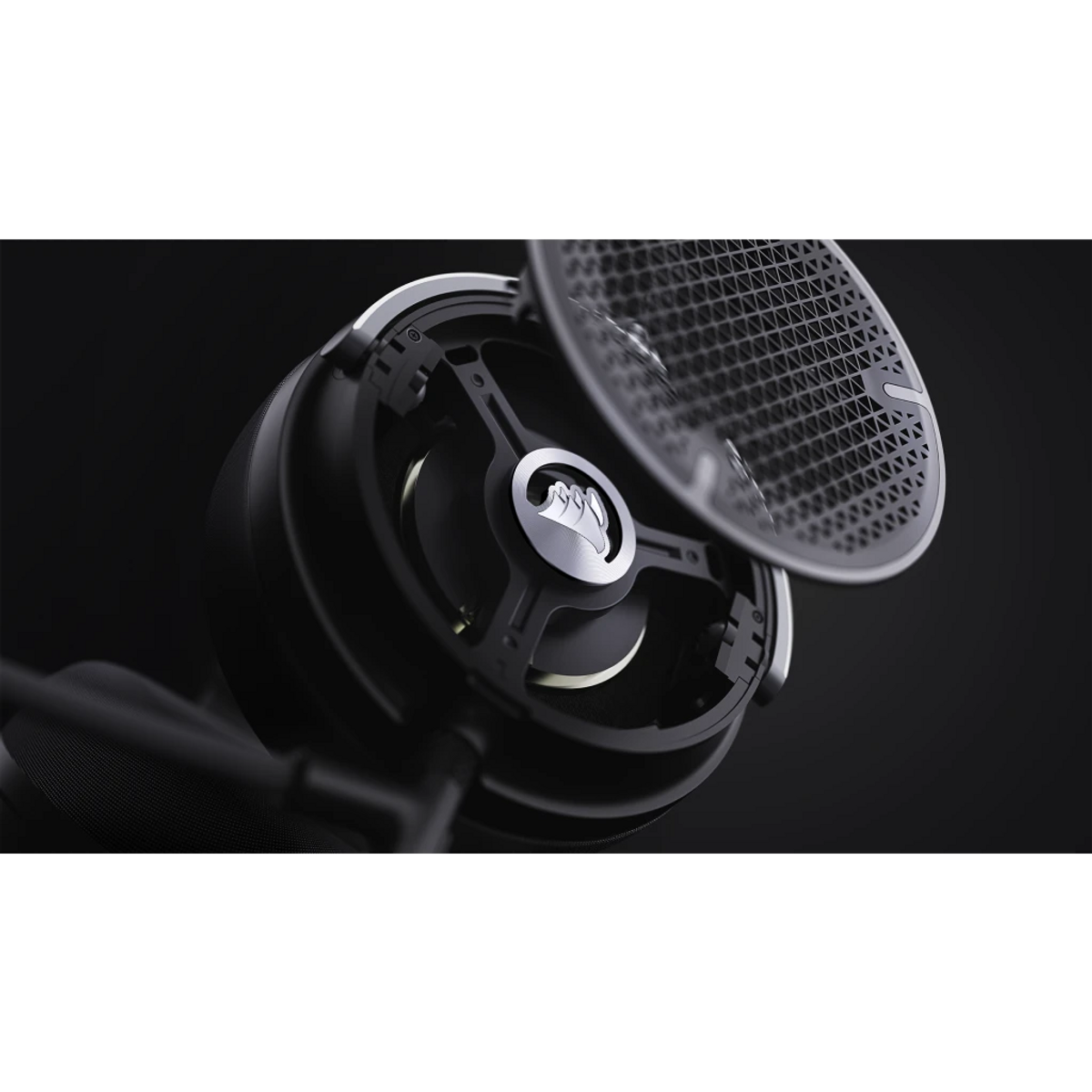 Zbliżenie czarnego zestawu słuchawkowego ze srebrnym logo. Część zestawu słuchawkowego jest otwarta, ukazując elementy wewnętrzne. Ciemne tło.