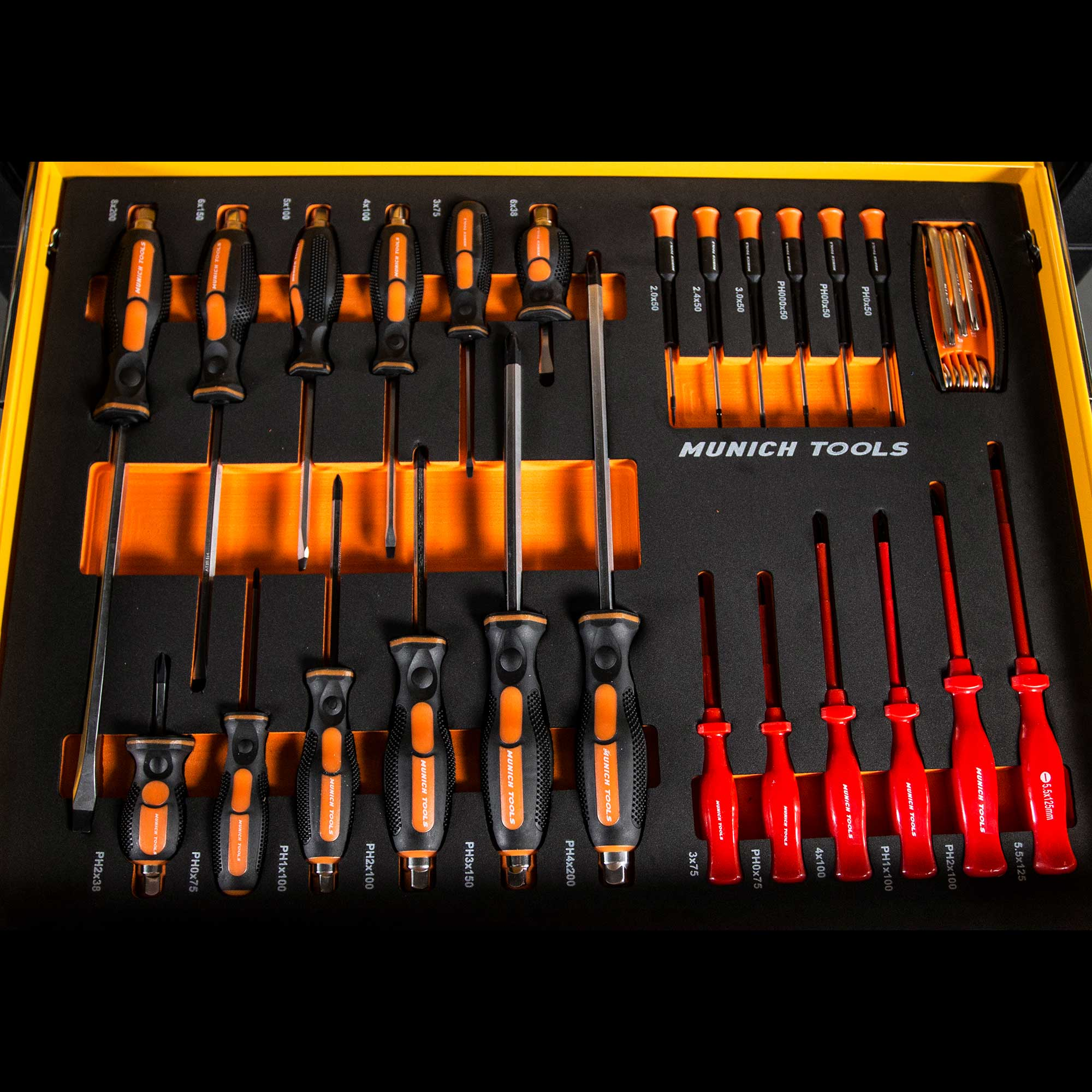 Un juego de herramientas. Destornilladores en una bandeja con mangos naranjas y negros, organizados por tamaño y tipo. 'MUNICH TOOLS' impreso.