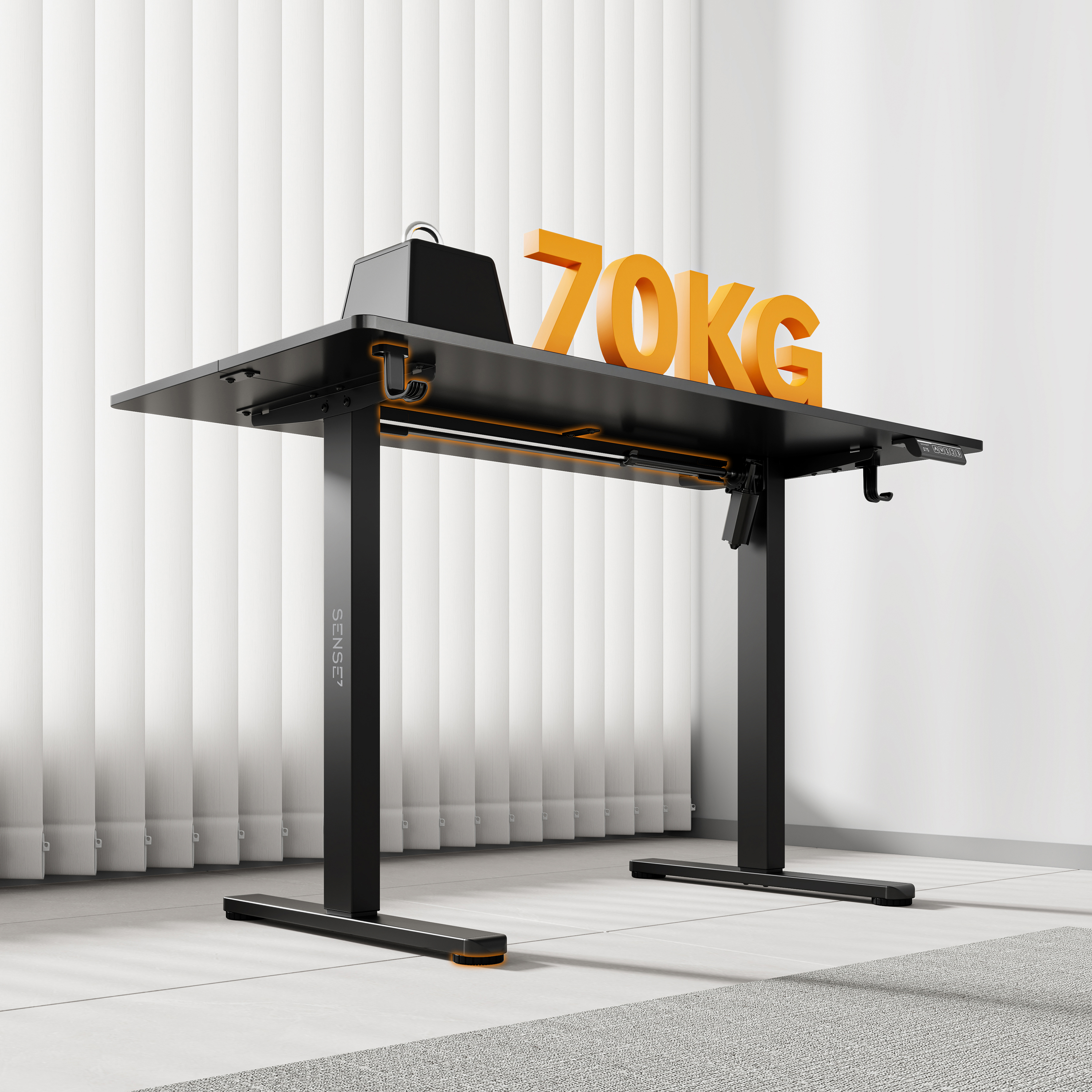 Zwarte staande bureau met oranje accenten. Grote oranje '70KG' erbovenop. Witte jaloezieën op de achtergrond. Lichtgrijs tapijt.