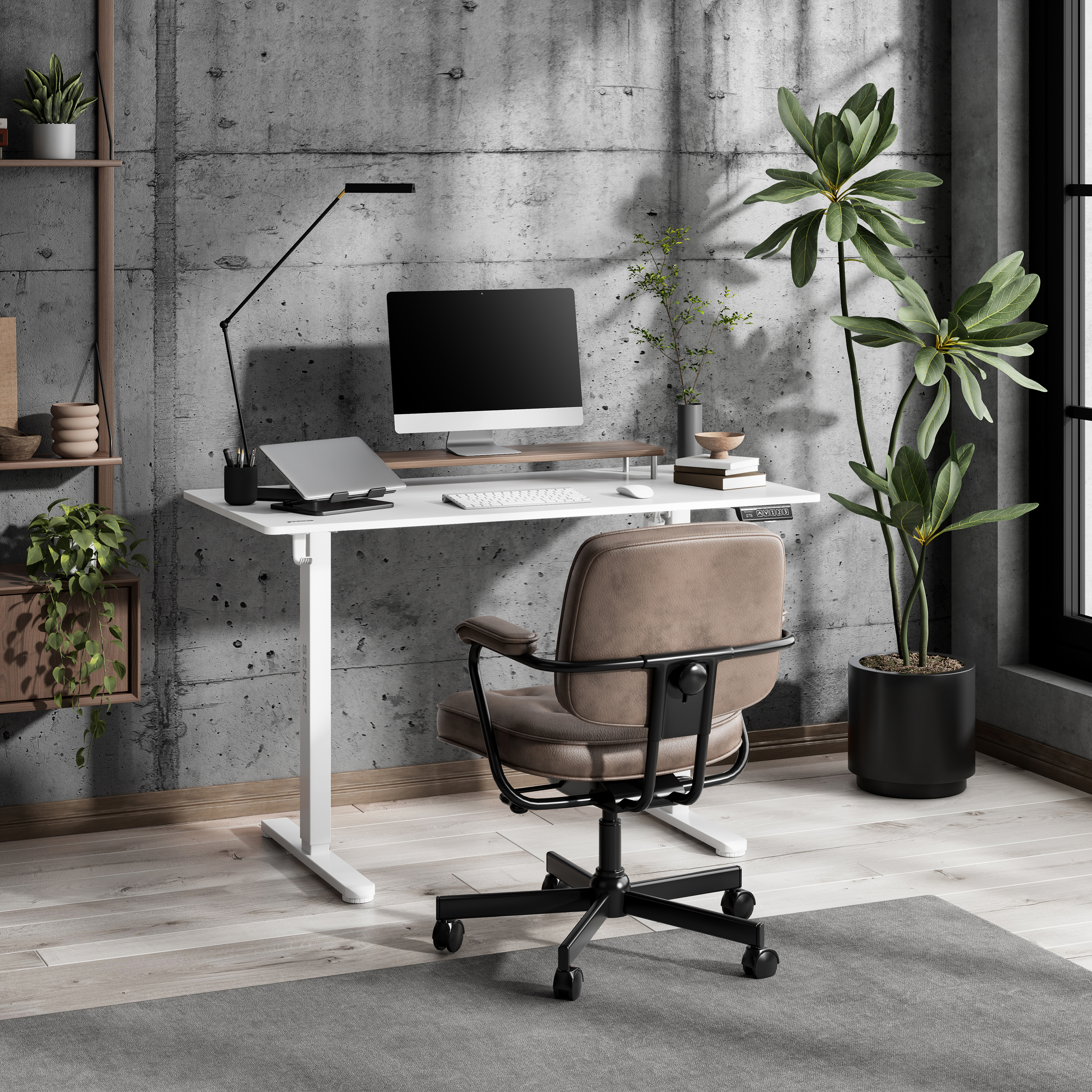 Een moderne kantooropstelling met een witte bureau, computer en leren stoel. Betonnen muur en plant op de achtergrond.