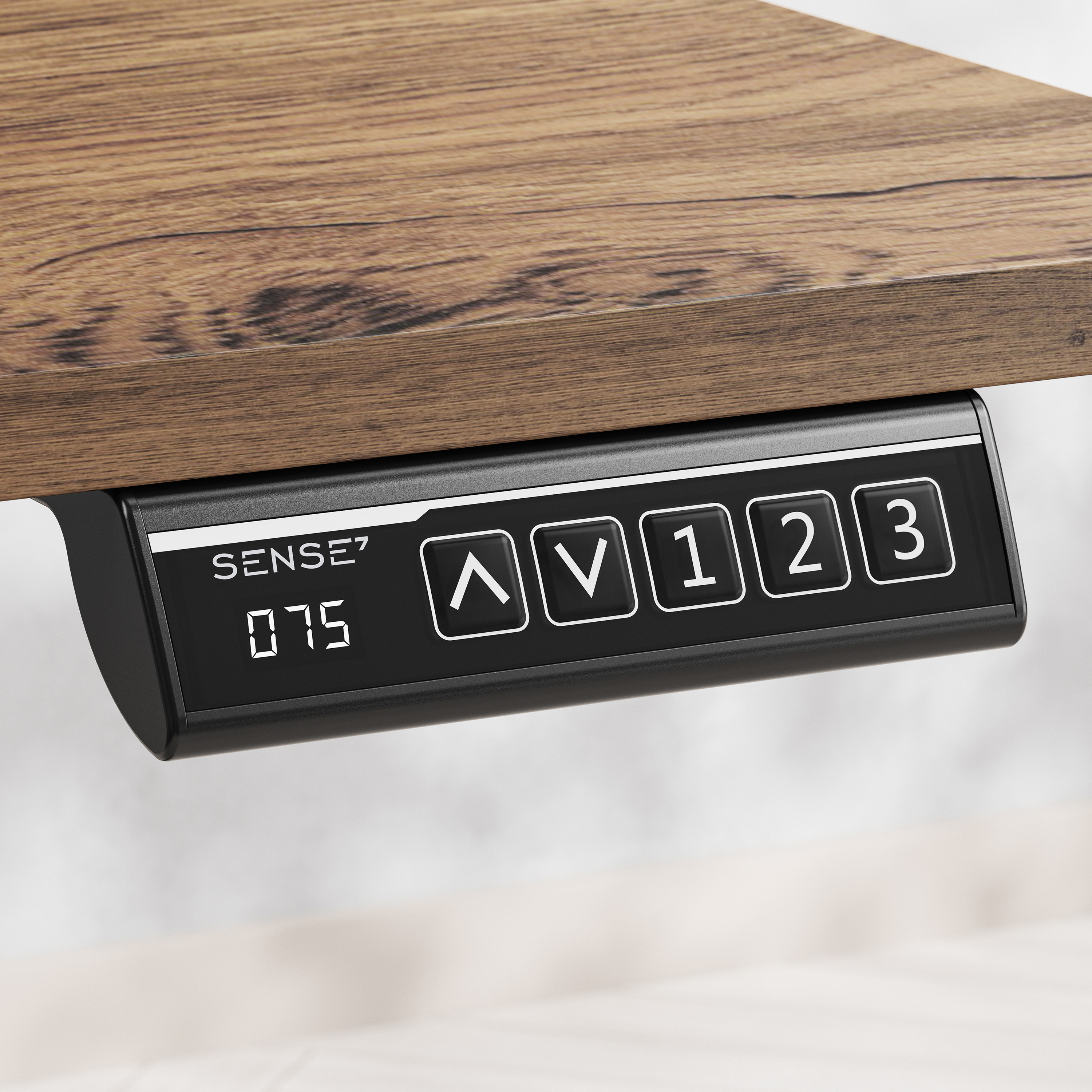 Nahaufnahme einer schwarzen Steuerung unter einem Holztisch. Sie zeigt Knöpfe und eine digitale Anzeige.