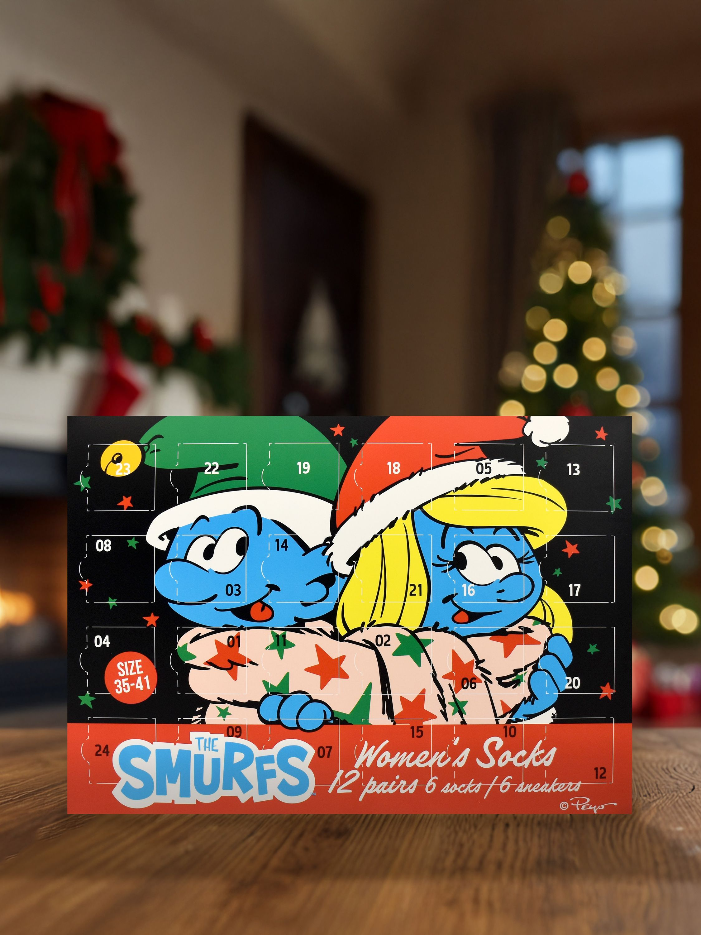 Ein Adventskalender mit Schlümpfen. Er hat Zahlen und Sterne. Ein Weihnachtsbaum und Kamin sind im verschwommenen Hintergrund.