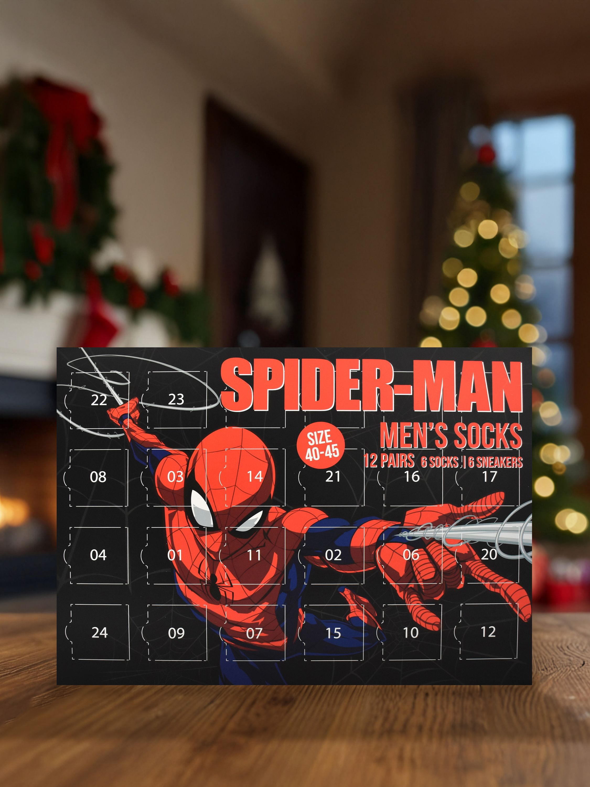 Spider-Man Adventskalender. Roter und blauer Charakter auf schwarzem Hintergrund. Zahlen 01-24. Weihnachtsbaum im Hintergrund.