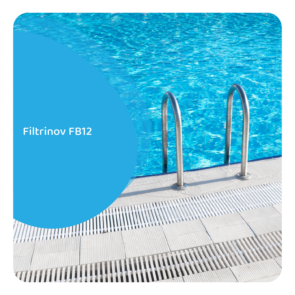 Una piscina con acqua blu limpida. Corrimano in acciaio inossidabile sono nella piscina. Piastrelle bianche circondano la piscina.