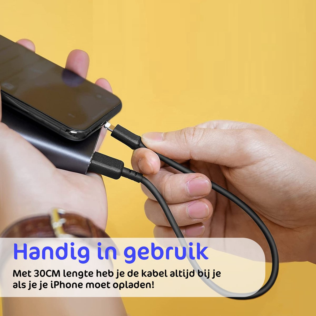 Een hand houdt een telefoon en een zwarte oplaadkabel vast. De kabel verbindt met de telefoon en een powerbank. Gele achtergrond.