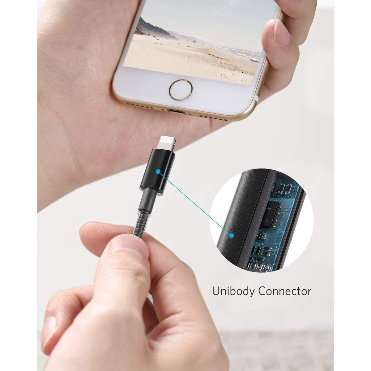 Een hand houdt een telefoon vast die is aangesloten op een zwarte oplaadkabel. Detail van de unibody-connector wordt getoond. De telefoon toont een strand.
