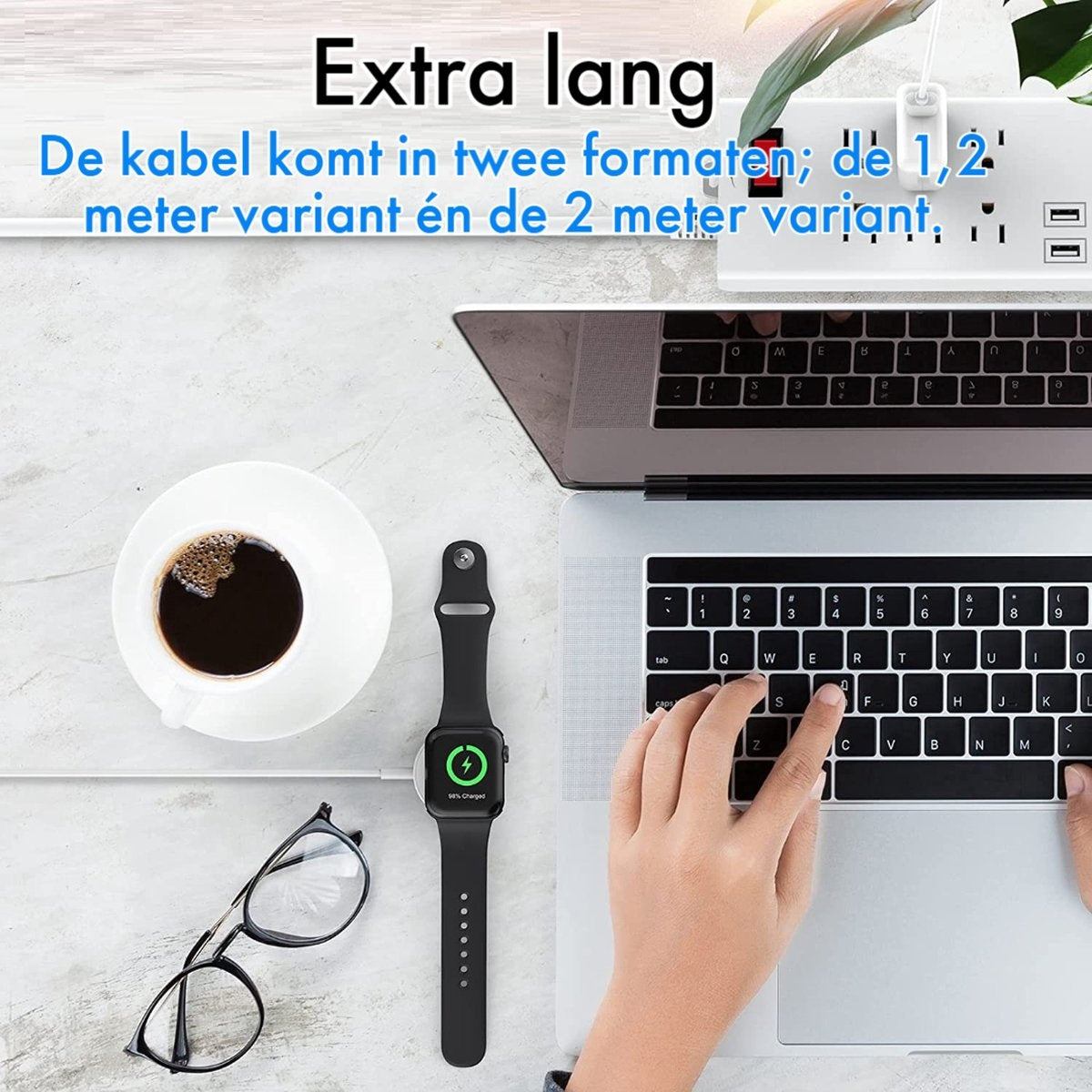 Een laptop, koffie, een bril en een oplaadbare smartwatch liggen op een bureau. Een hand typt. Een stekkerdoos is zichtbaar.
