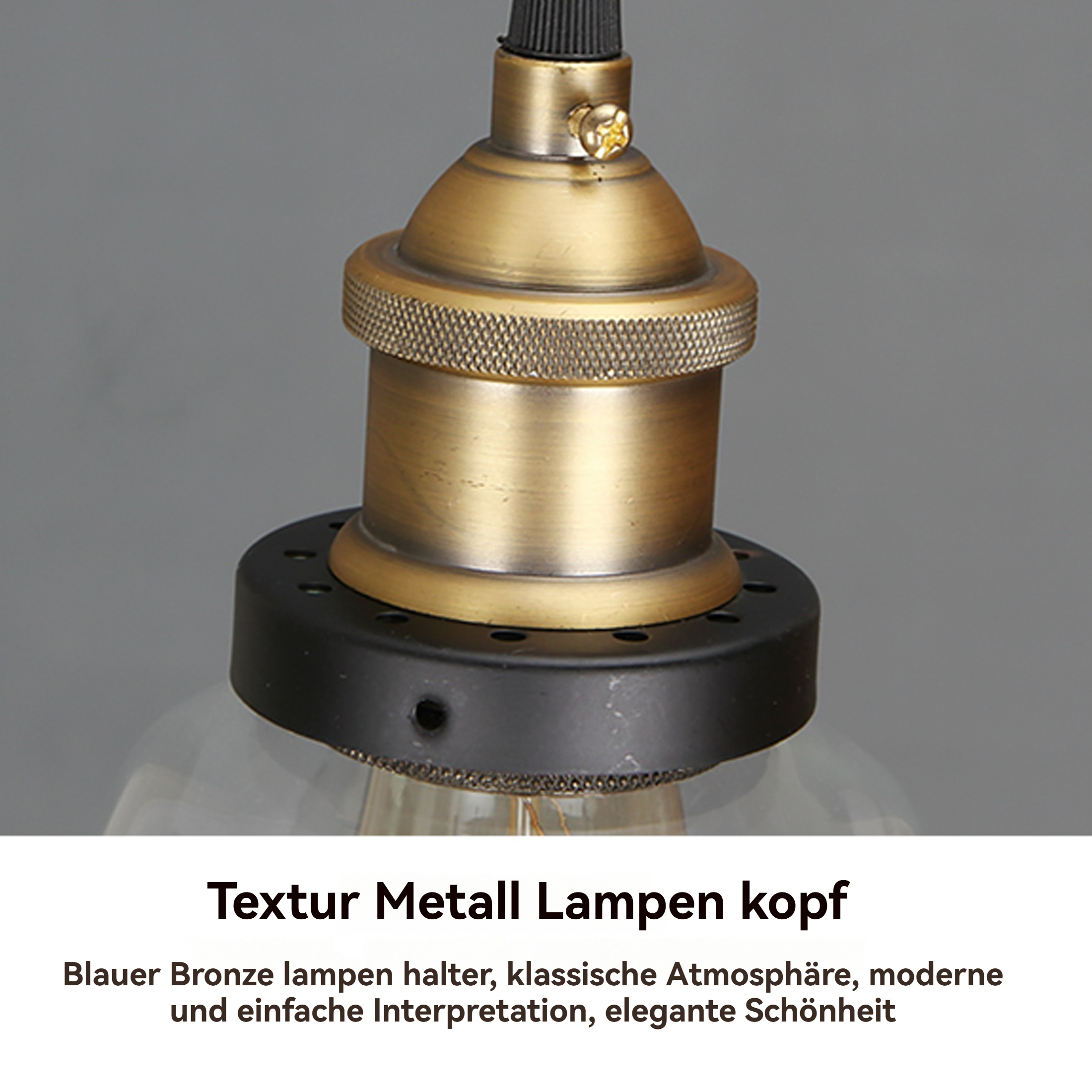 Nahaufnahme eines bronzefarbenen Lampenkopfes. Die Lampe hat einen schwarzen Sockel und eine klare Glühbirne. Der Hintergrund ist grau.
