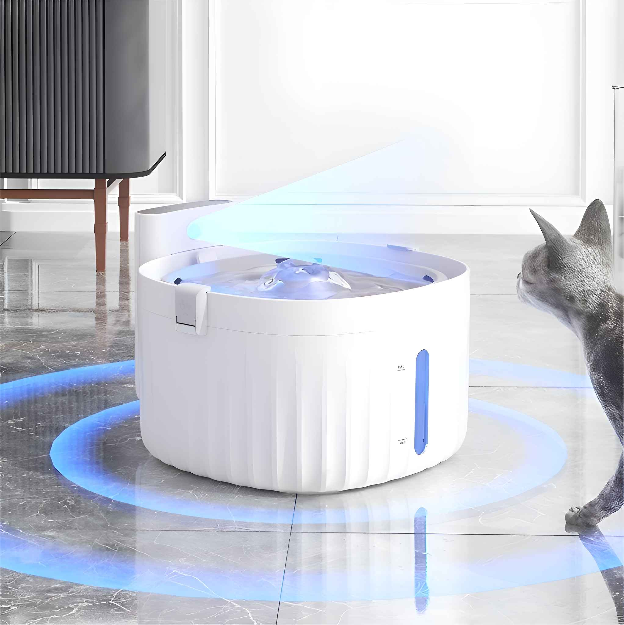 Ein weißer Katzenwasserbrunnen, eine graue Katze schaut ihn an. Blaues Licht geht vom Brunnen aus. Im Hintergrund ein Schrank.
