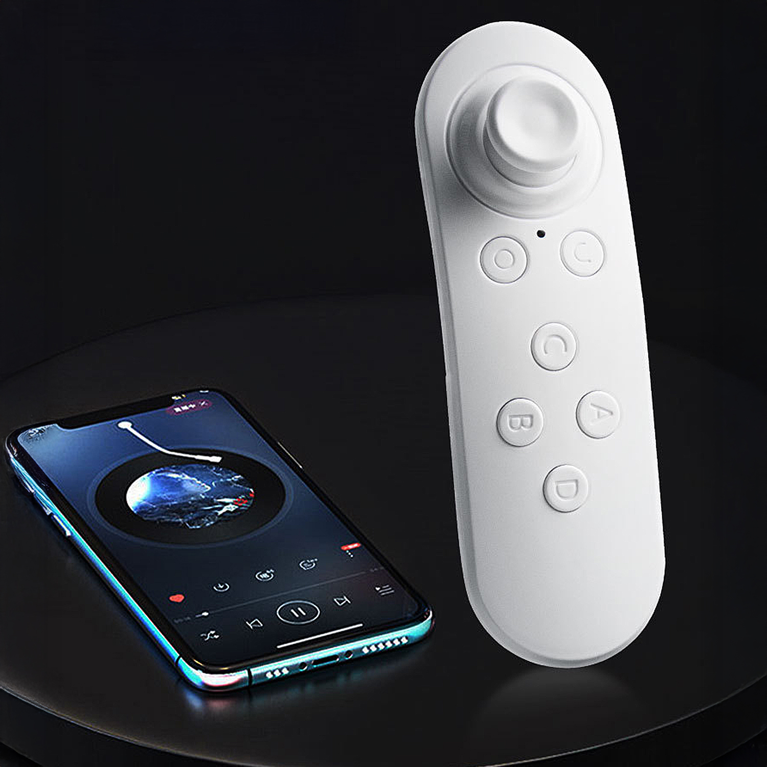 Un telecomando bianco e uno smartphone sono su una superficie nera. Il telefono mostra un'app musicale. Il telecomando ha pulsanti e un joystick.