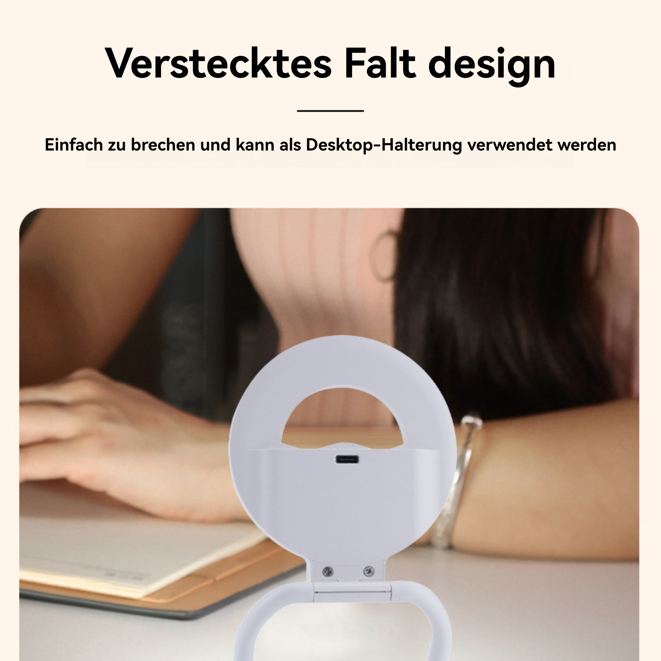 Ein weißes Ringlicht steht auf einem Tisch. Die Arme einer Person und ein Notizbuch sind ebenfalls sichtbar. Der Hintergrund ist unscharf.