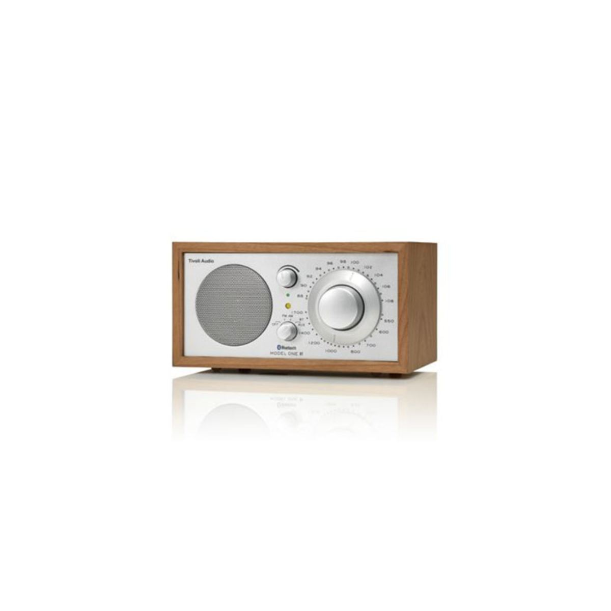Ein Holzradio mit silberner Front. Es hat einen Lautsprecher, ein Einstellrad und Bedienknöpfe. Das Radio ist mit 'Model One' beschriftet.
