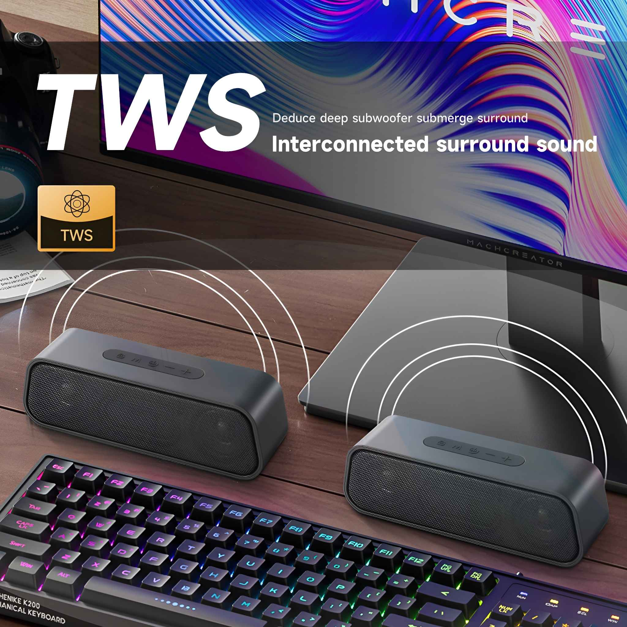 Zwei schwarze Lautsprecher stehen auf einer Holzoberfläche, im Vordergrund befindet sich eine Tastatur. Display im Hintergrund.