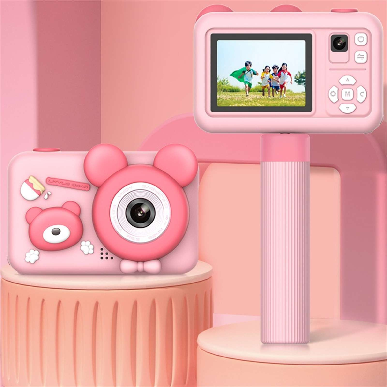Rosa Spielzeugkamera mit Bärenohren und einem Bildschirm, auf dem Kinder laufen. Die Kamera steht auf einem pfirsichfarbenen Ständer, mit rosa Hintergrund.