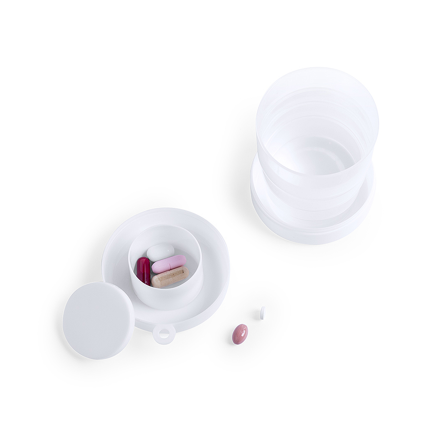Contenedor de pastillas blanco con pastillas dentro y dispersas. Fondo blanco. Las pastillas son rosas, rojas y beige.