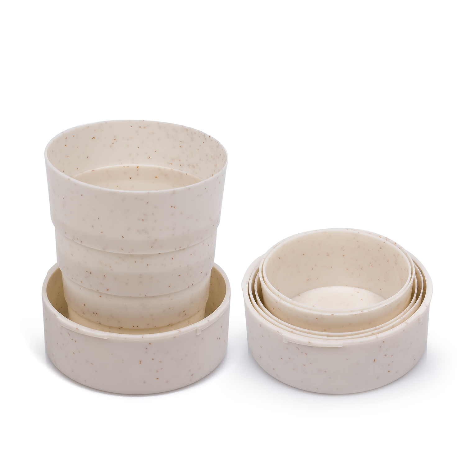 Taza y cuencos beige. La taza está abierta, los otros cuencos están anidados. Todos tienen motas marrones, sobre fondo blanco.
