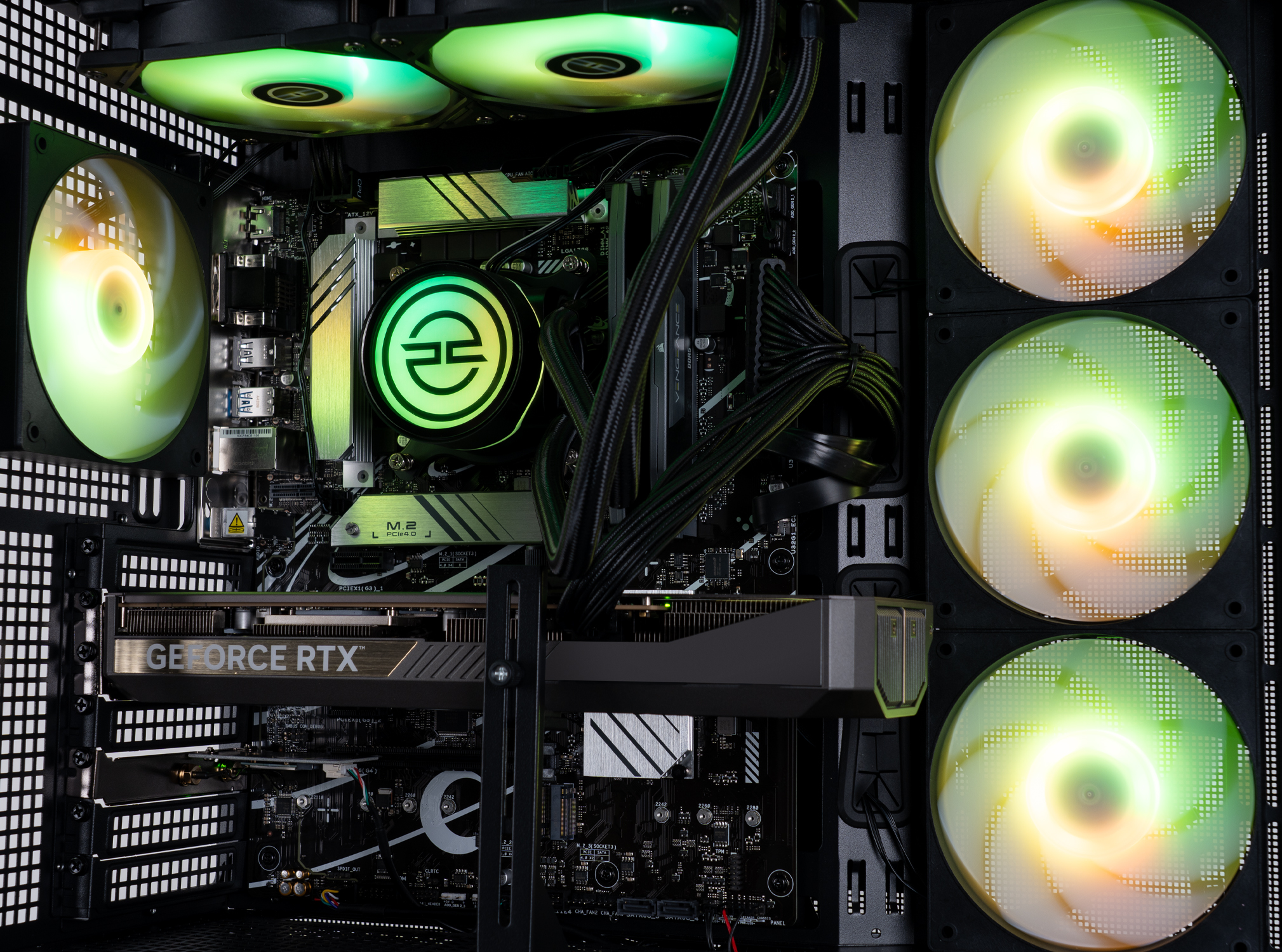 All'interno di un case di computer, ventole con luci verdi e gialle illuminano i componenti. Una scheda grafica e una scheda madre sono visibili.