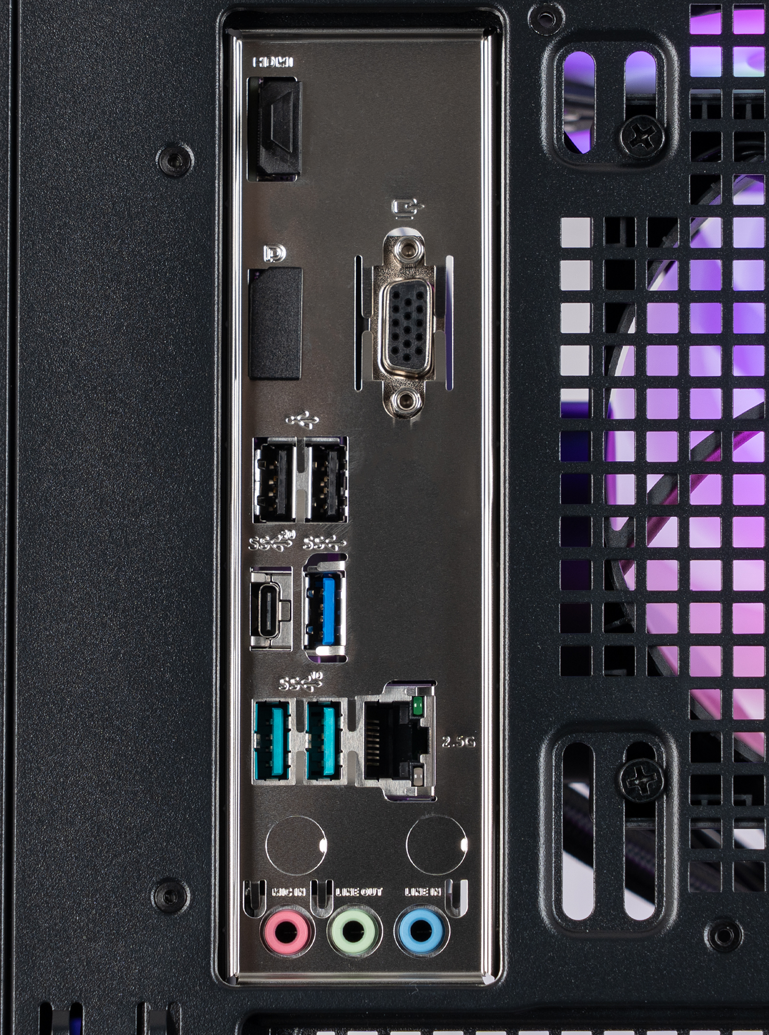 Primo piano del pannello posteriore di un computer. Presenta varie porte come USB, jack audio e un connettore VGA, con un case nero e illuminazione viola.