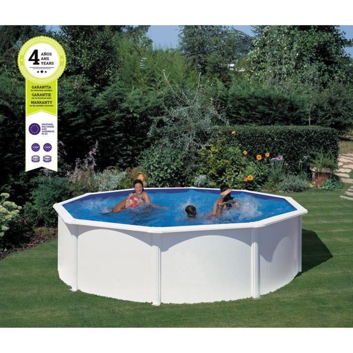 Niños jugando en una piscina blanca elevada en un jardín. Hierba verde y árboles rodean la piscina. Una etiqueta de garantía es visible.
