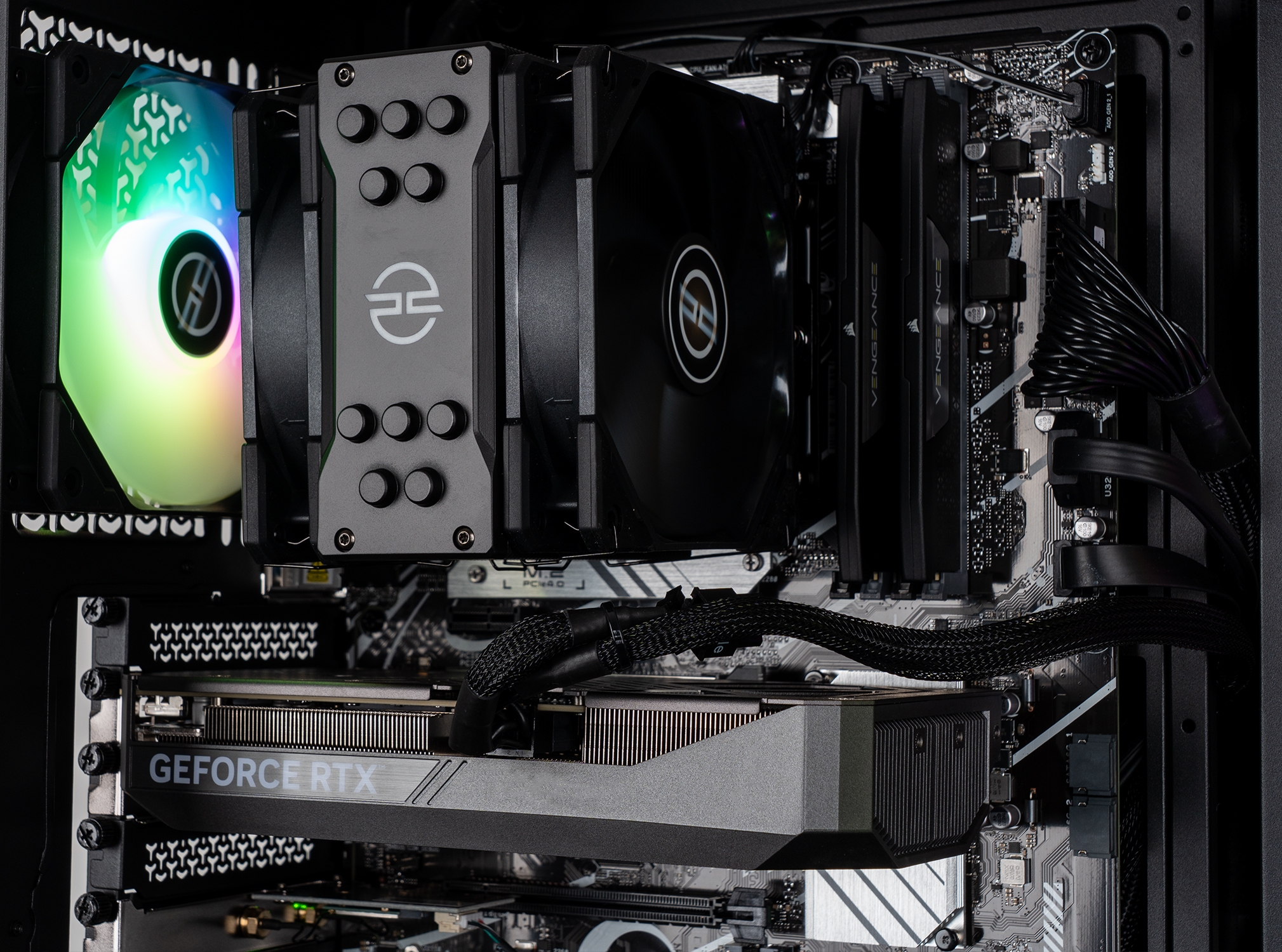 All'interno di un case di computer, un sistema di raffreddamento con ventole e una scheda grafica con testo 'GEFORCE RTX' sono visibili.