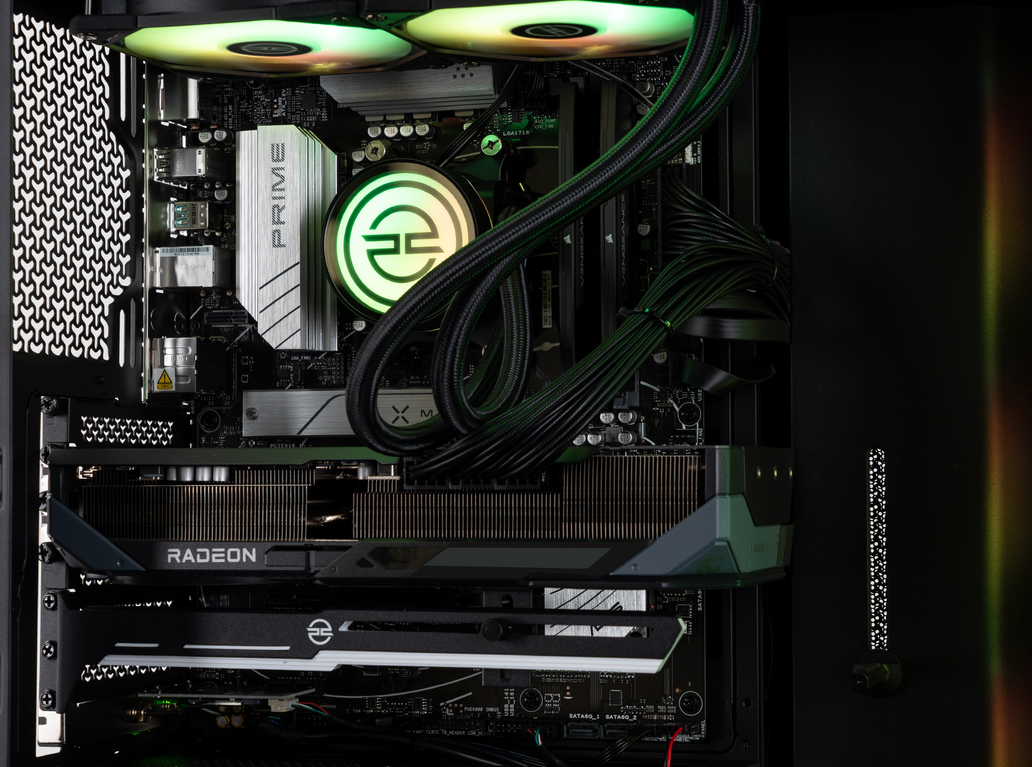 All'interno di un case di computer, una scheda grafica Radeon si trova sotto un dissipatore. Al centro un dissipatore CPU con logo verde.