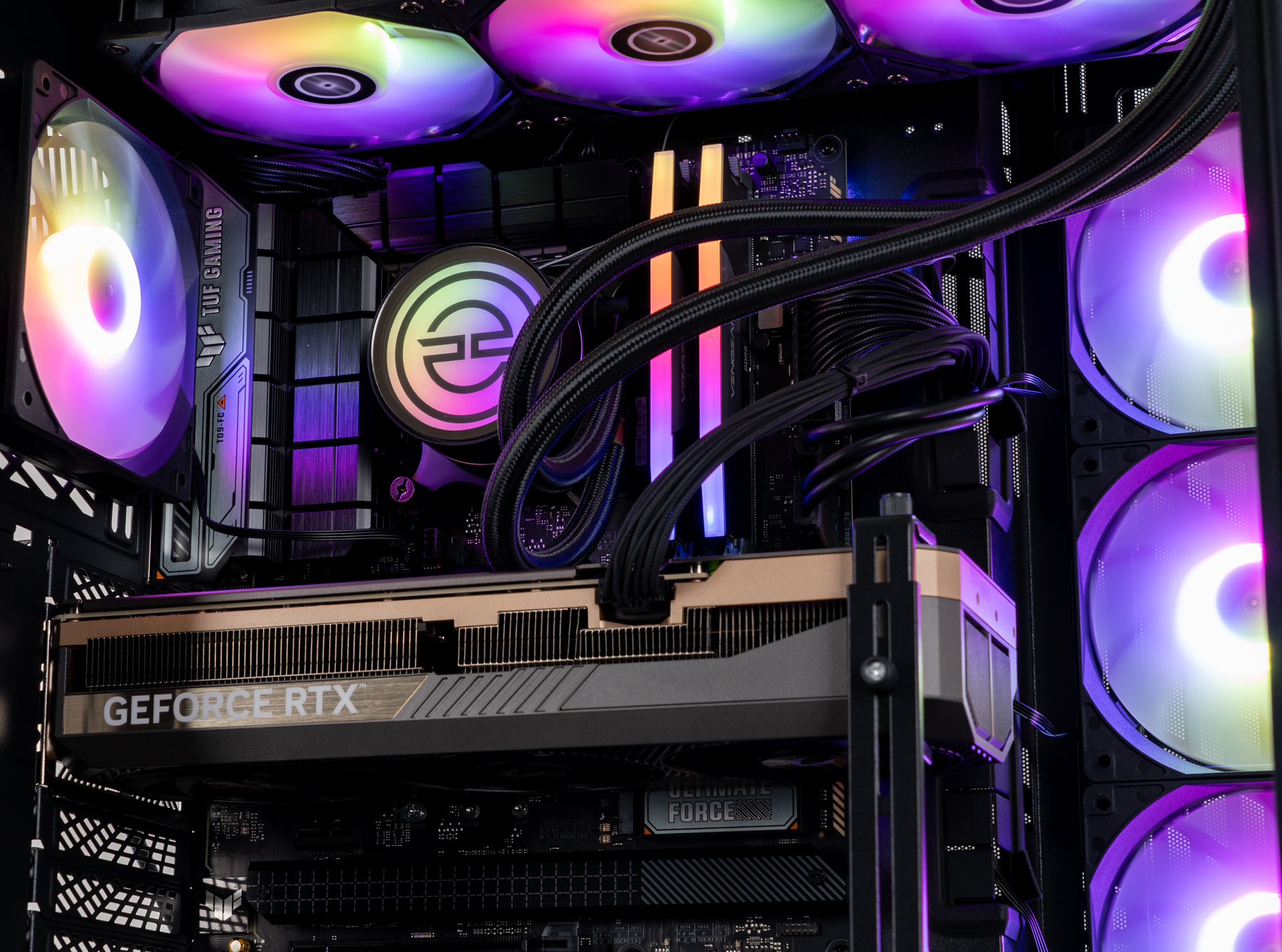 All'interno di un case di computer: una scheda grafica GeForce RTX, ventole con luci colorate e altri componenti sono visibili.