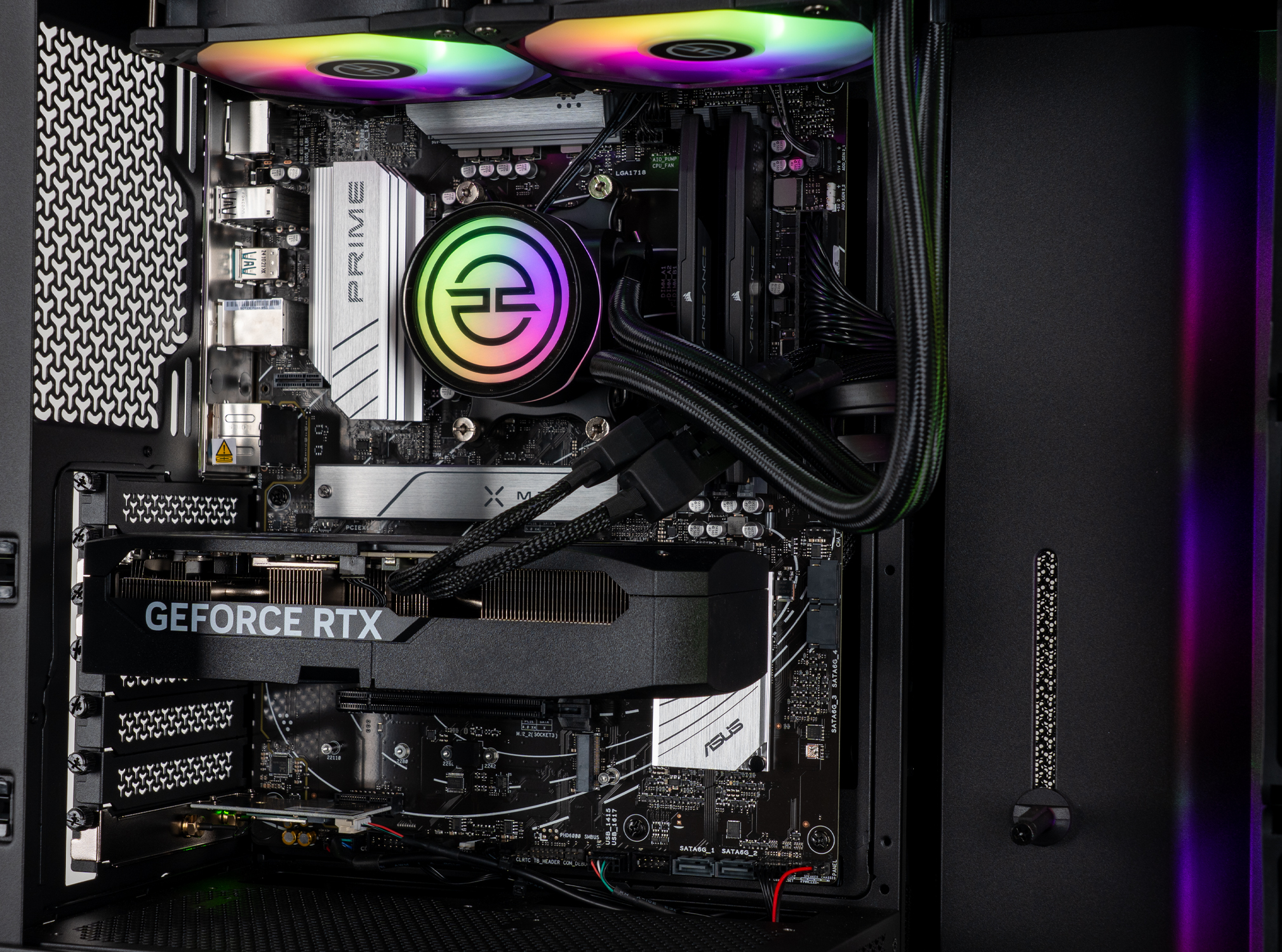 All'interno di un case per computer, sono visibili una scheda grafica, una scheda madre e un sistema di raffreddamento. I componenti sono neri e argento con illuminazione RGB.