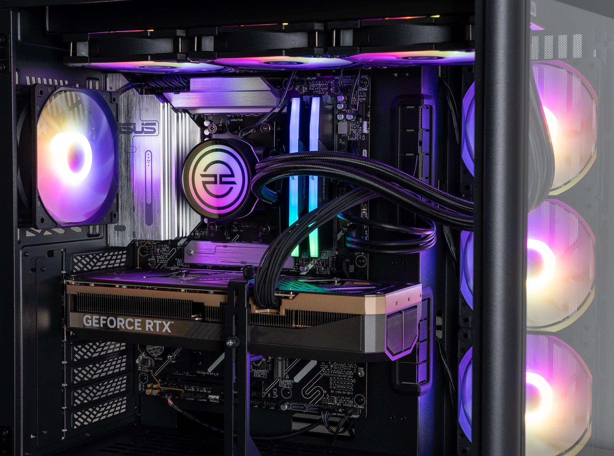 All'interno di un case per computer, una scheda grafica GeForce RTX, un dissipatore CPU e ventole colorate sono visibili. Il case è aperto.