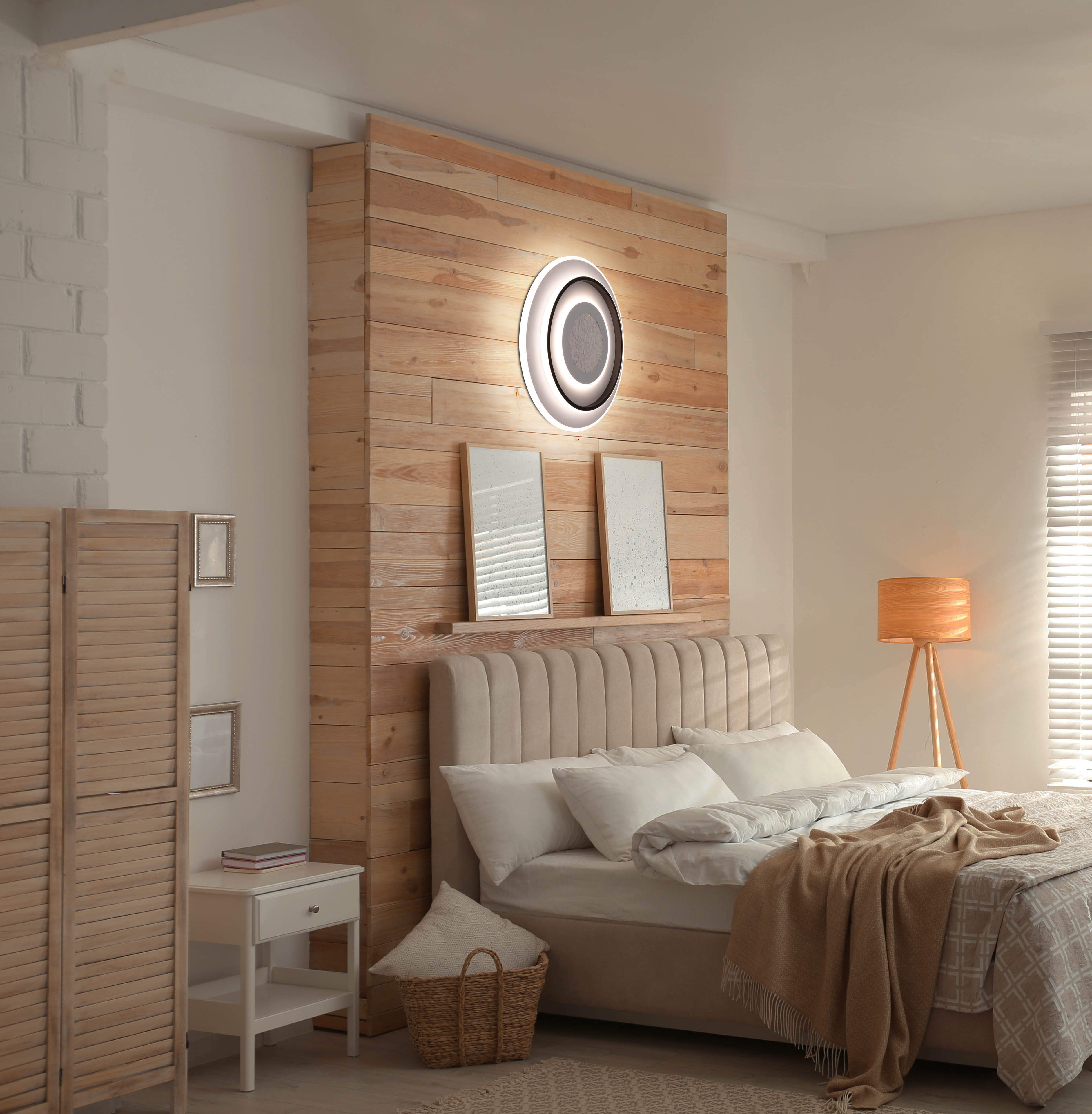 Schlafzimmer mit Bett, Holzwand und dekorativem Licht. Eine Lampe und eine Stellwand sind ebenfalls sichtbar.