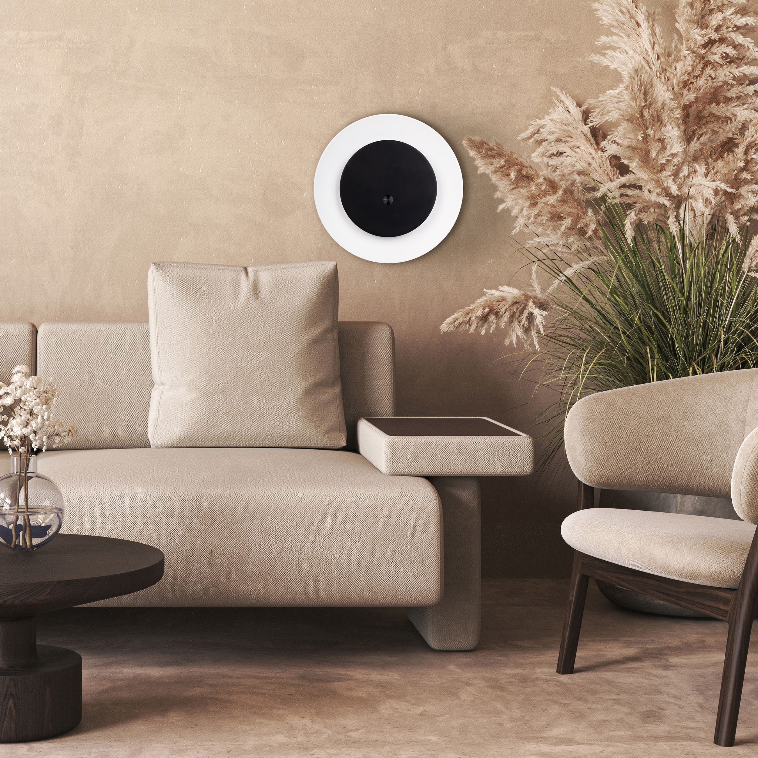 Beiges Sofa, Stuhl und runder Tisch. Wandmontiertes schwarz-weißes Kreiselement. Hohes Ziergras in einem Topf.