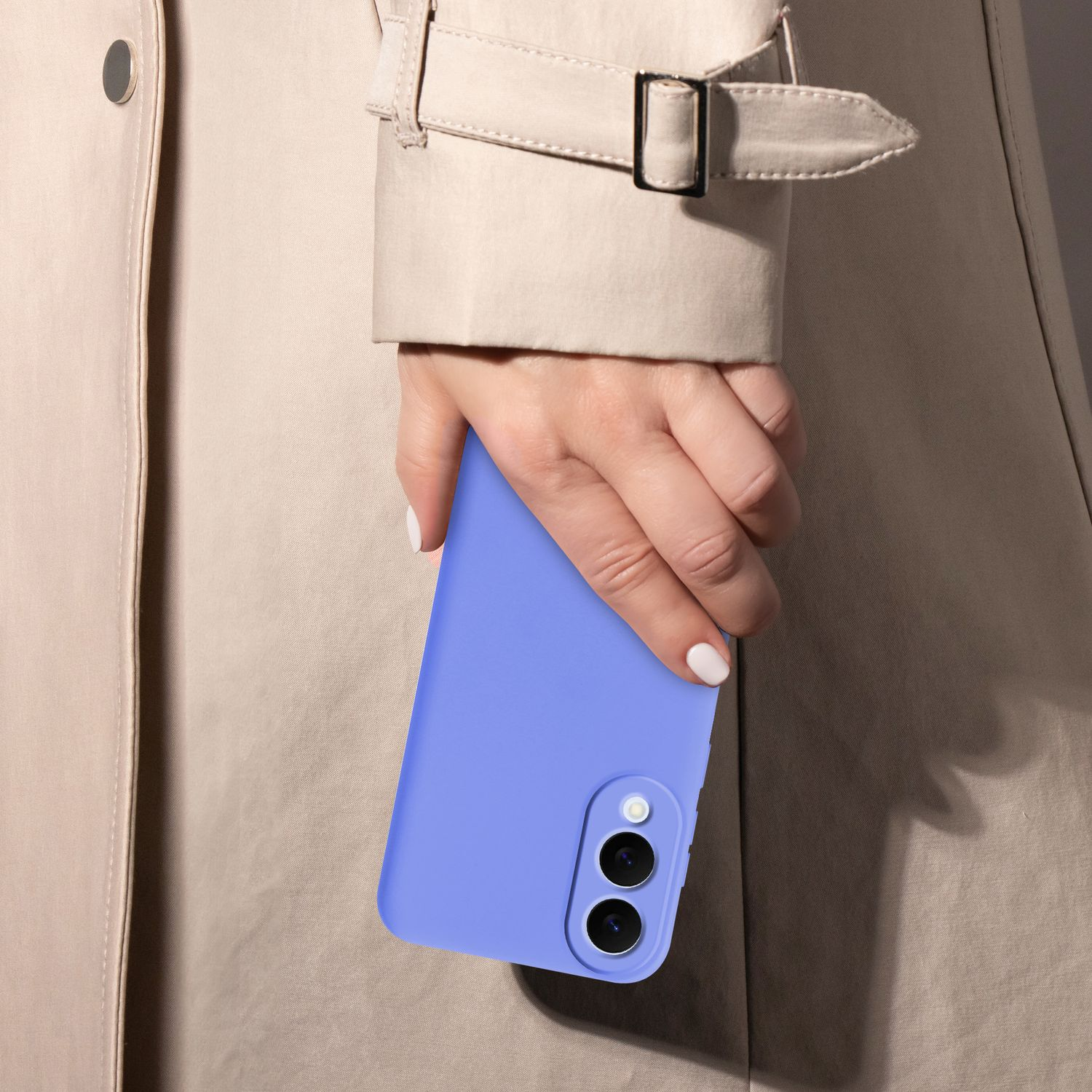 Eine Hand hält eine hellblaue Handyhülle. Die Hand trägt weißen Nagellack. Der Hintergrund zeigt einen beigefarbenen Trenchcoat.