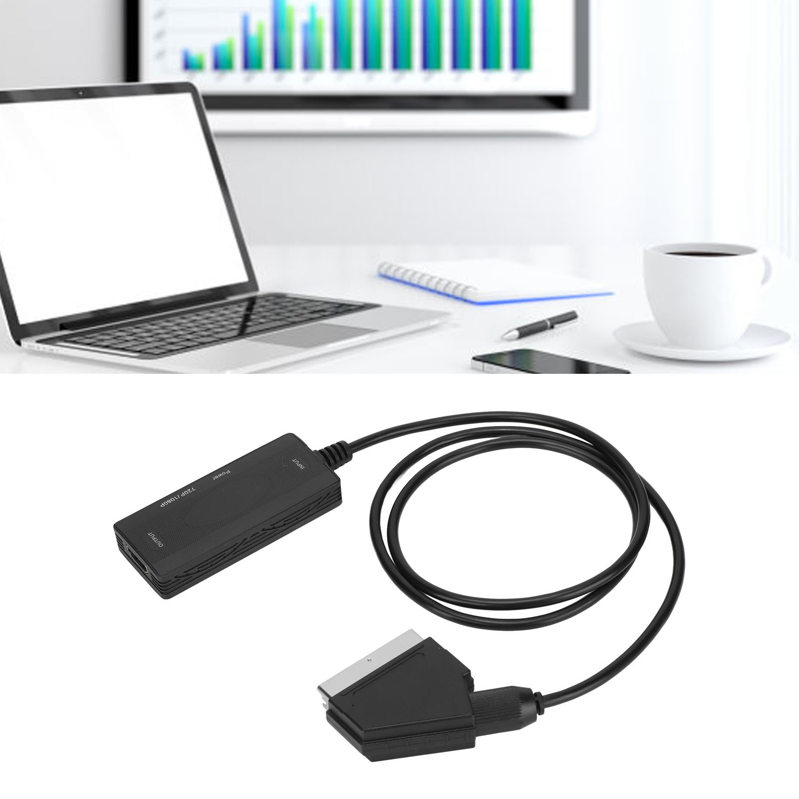 Ein Laptop, eine Kaffeetasse und ein Kabel mit SCART-Anschluss stehen auf einem weißen Schreibtisch. Im Hintergrund ist ein Diagramm zu sehen.
