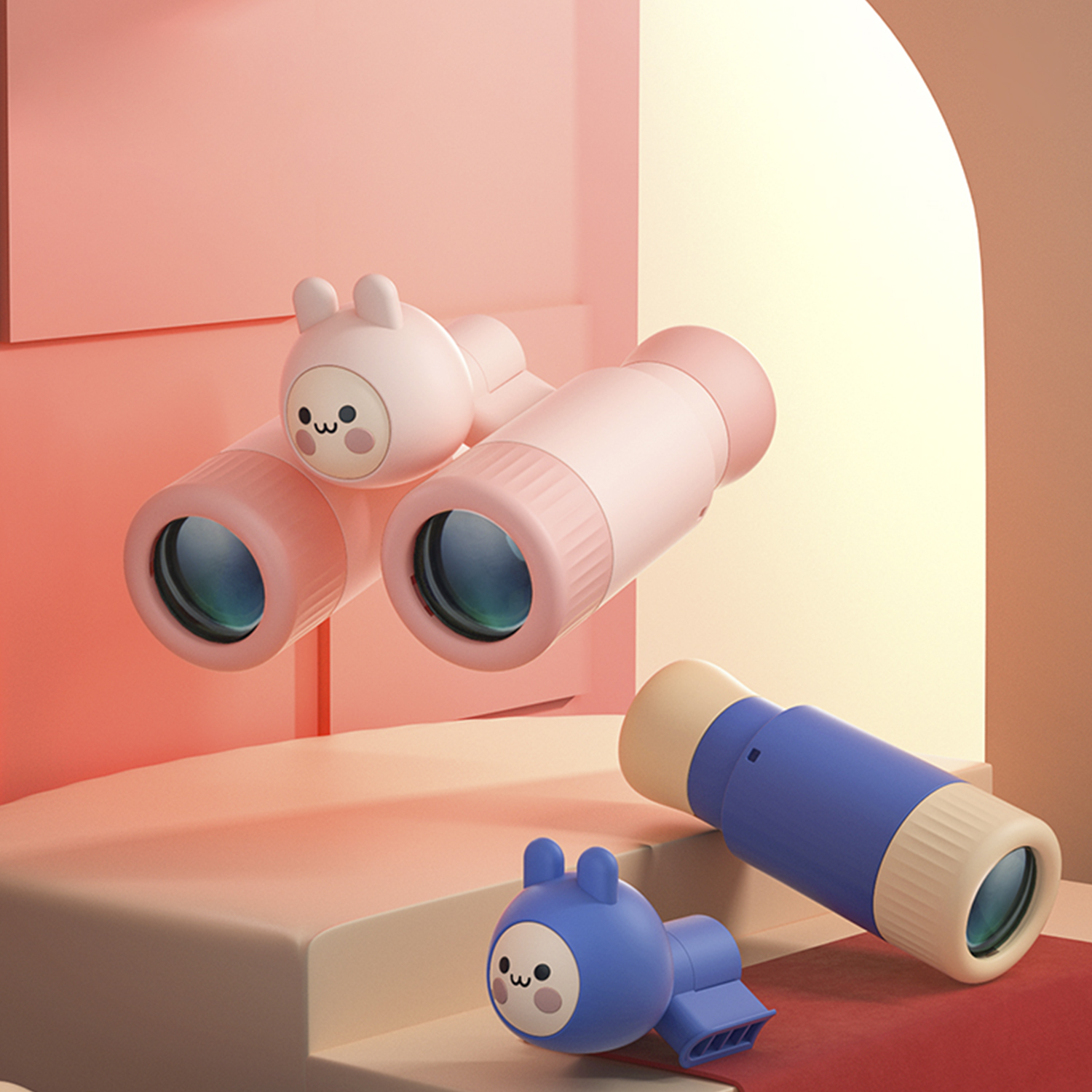 Prismáticos y telescopio de juguete rosas y azules. También hay una figura de juguete azul con orejas de conejo.