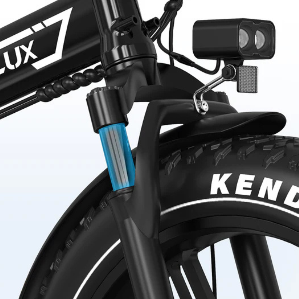 Zbliżenie przedniej części czarnego roweru elektrycznego. Przednia opona pokazuje markę KENDA. Zawieszenie ma niebieską rurę. Zamontowany jest reflektor.