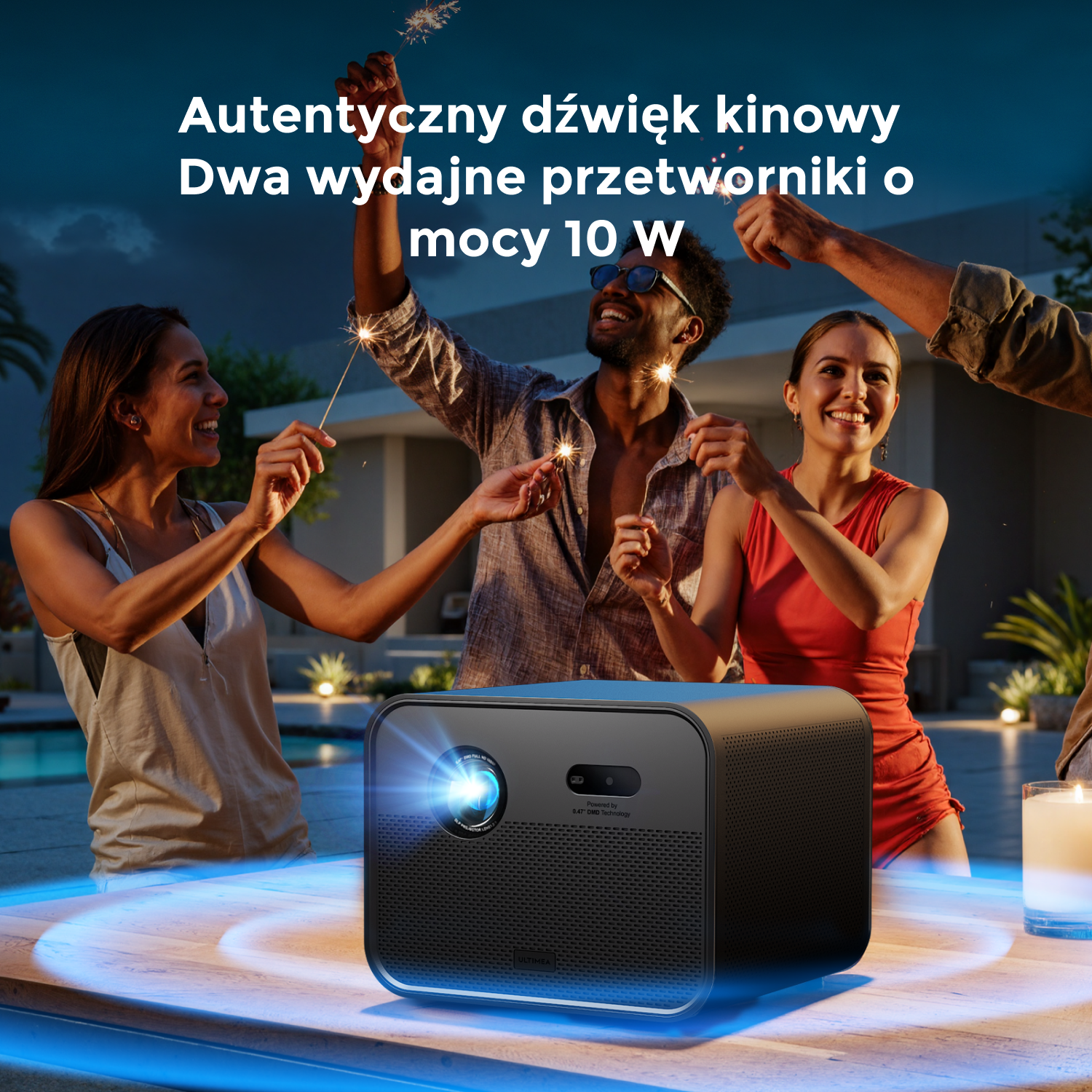 Ludzie z zimnymi ogniami wokół projektora na stole. Tekst brzmi: Autentyczny dźwięk kinowy. Dwa wydajne przetworniki 10W.