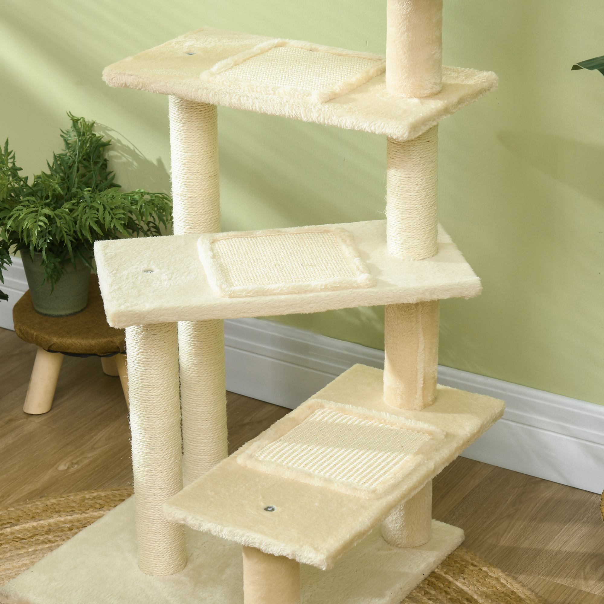 Un árbol para gatos beige con múltiples plataformas y postes rascadores. A la izquierda hay un taburete pequeño con una planta.