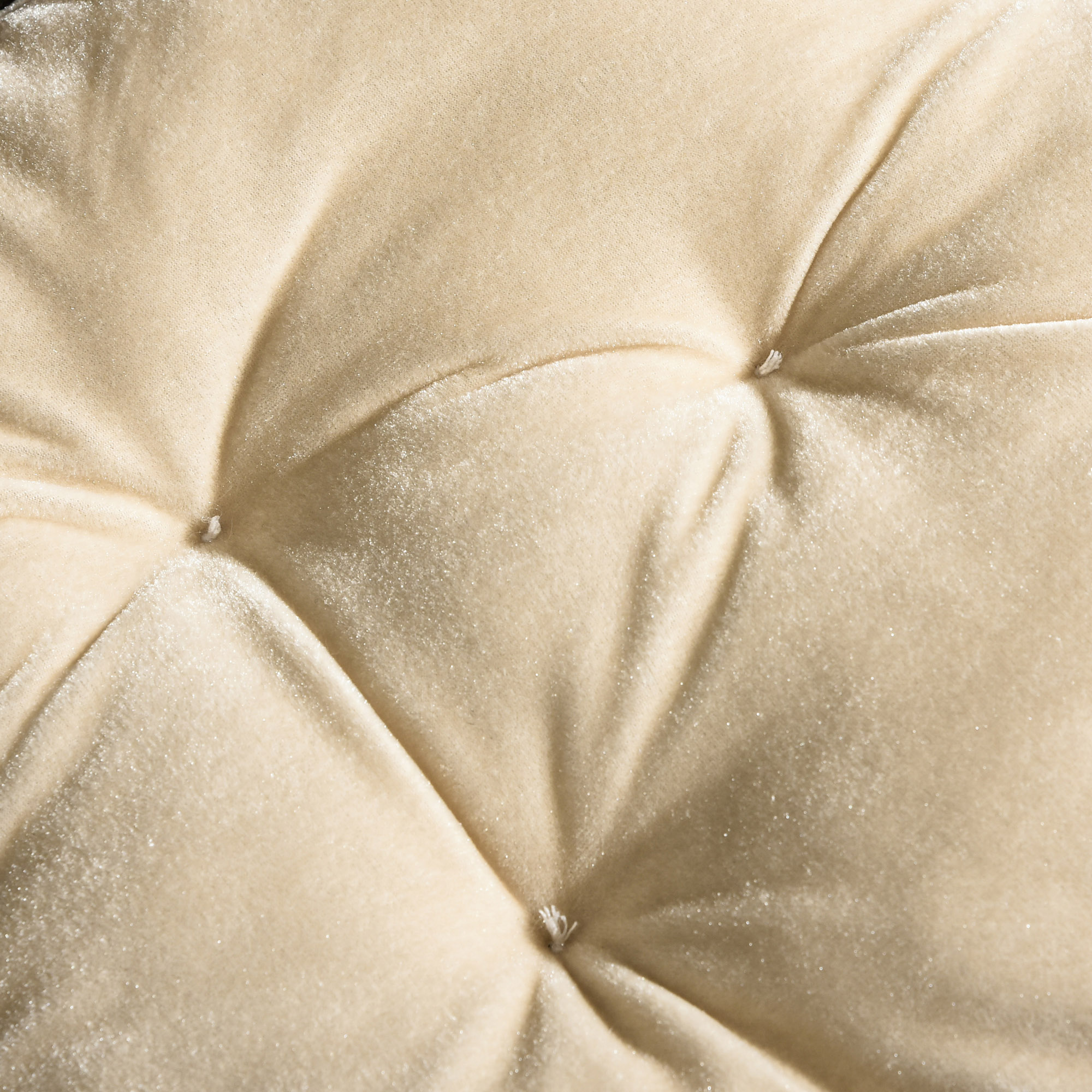 Primer plano de tela beige acolchada. El patrón de diamantes tiene puntadas en las intersecciones. Textura suave y aterciopelada.