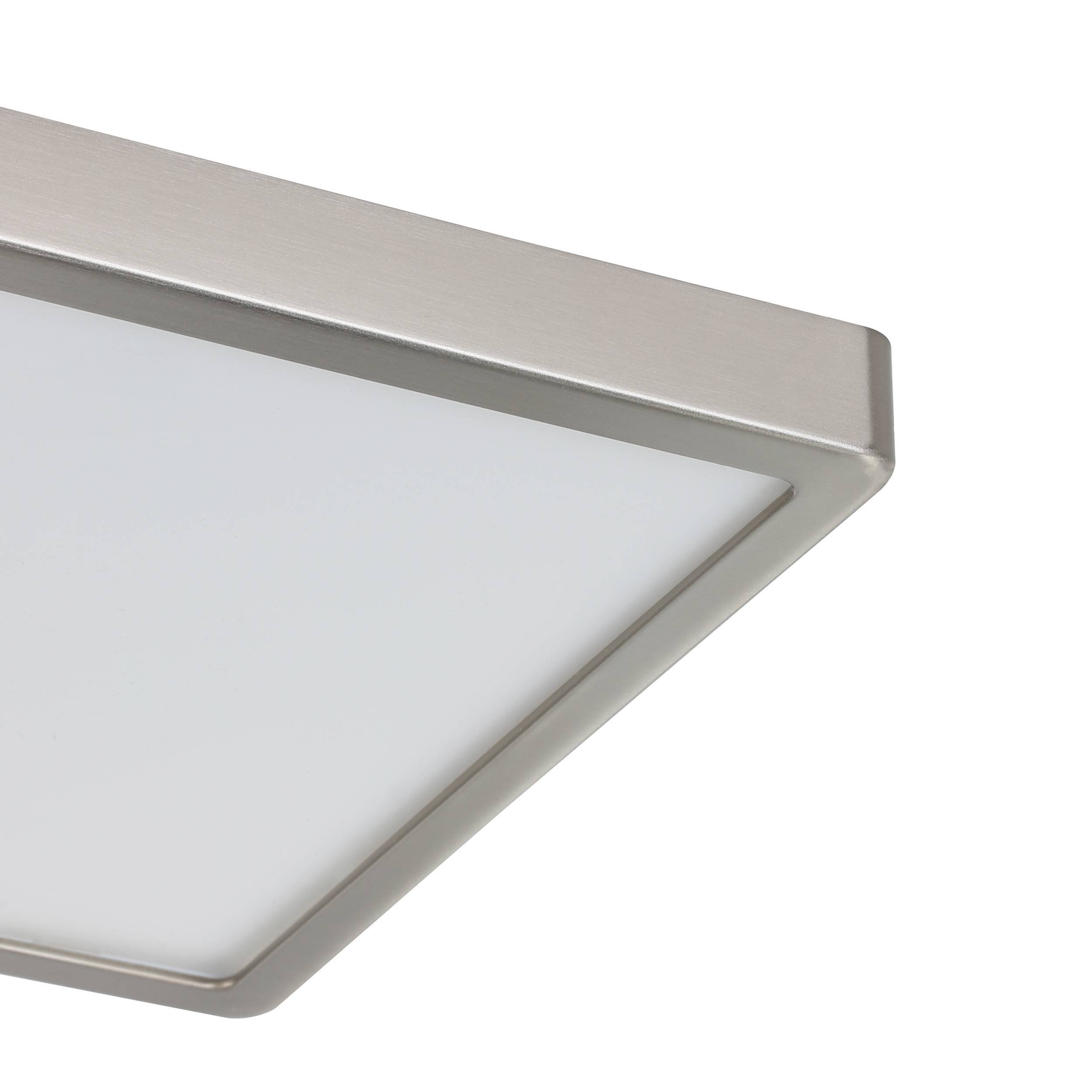 Primo piano di un moderno apparecchio per illuminazione a soffitto quadrato. Ha una cornice in metallo spazzolato e un pannello luminoso bianco traslucido.