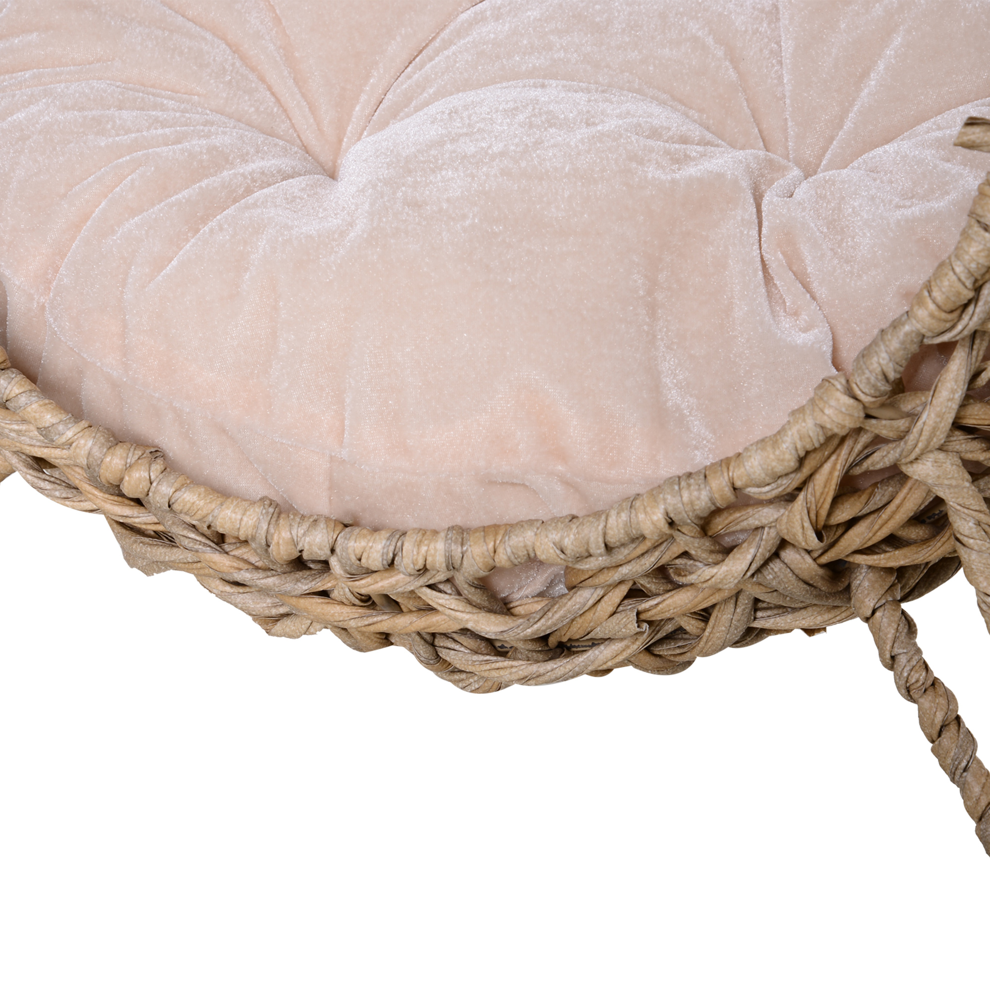 Primer plano de una silla. Un marco de mimbre tejido sostiene un cojín rosa claro y acolchado.