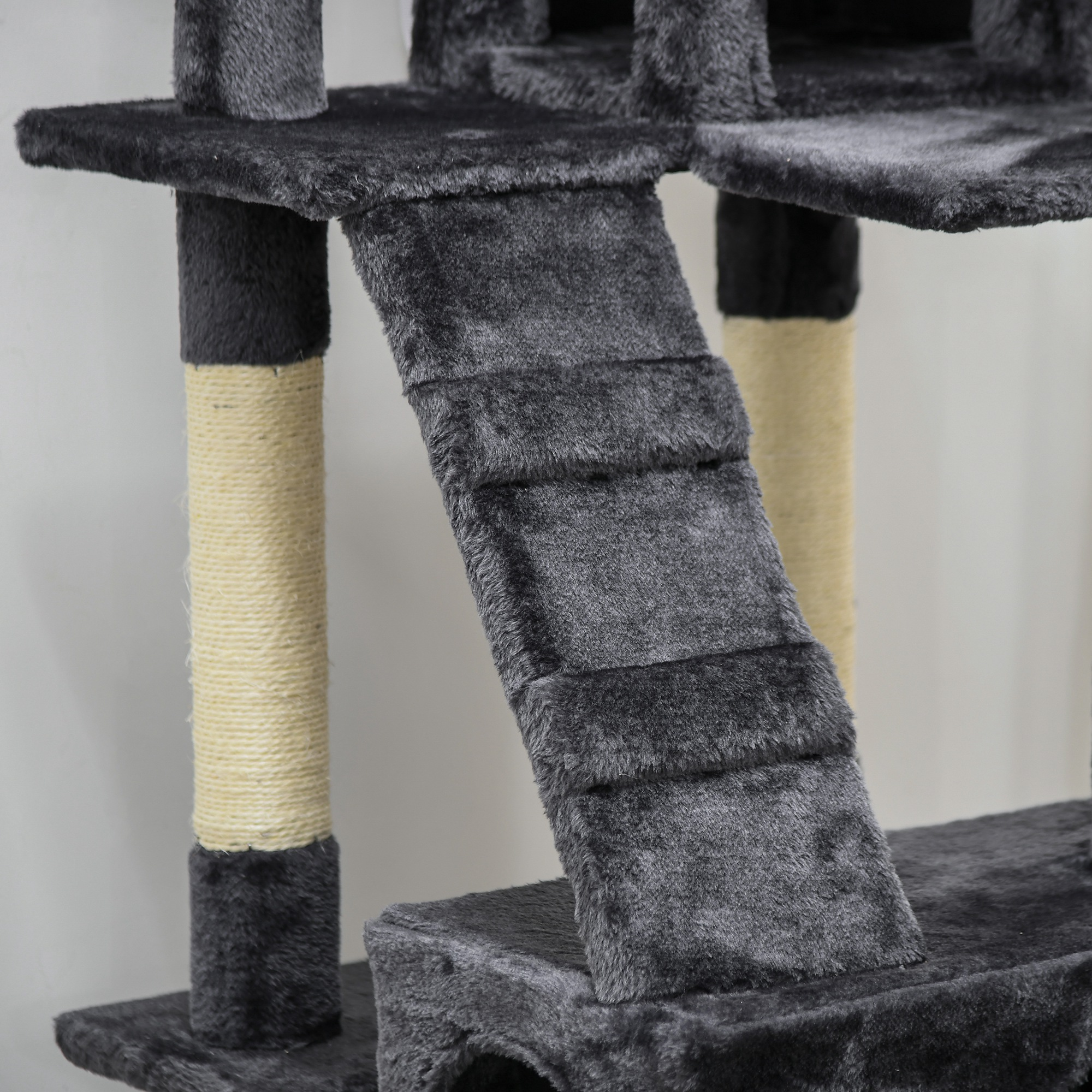 Un árbol para gatos gris con múltiples niveles. Una escalera y postes envueltos en cuerda son visibles. El fondo es blanco.