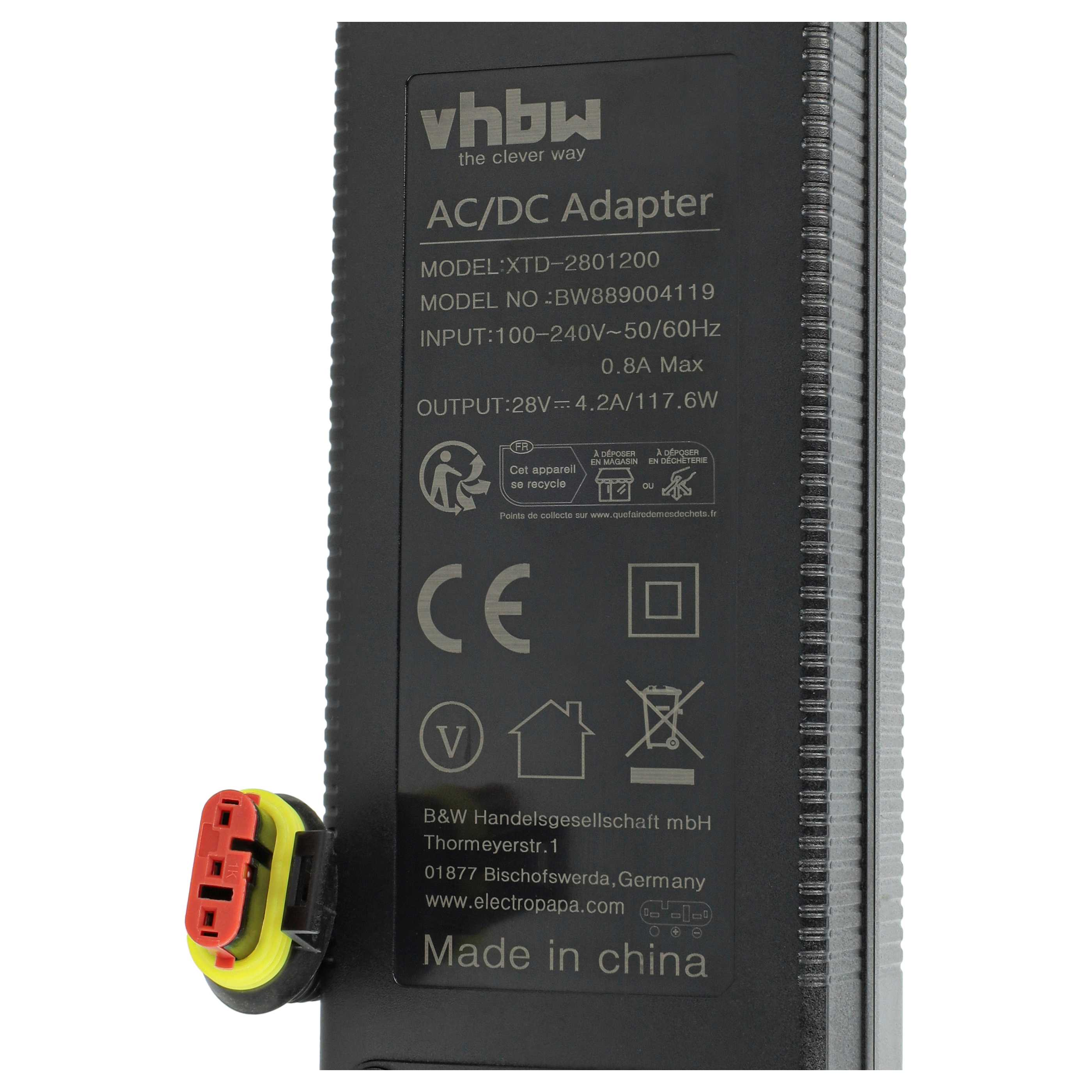 Ein AC/DC-Adapter mit Text, Logos und einem rot-gelben Stecker. Schwarzer Hintergrund mit weißem Text.