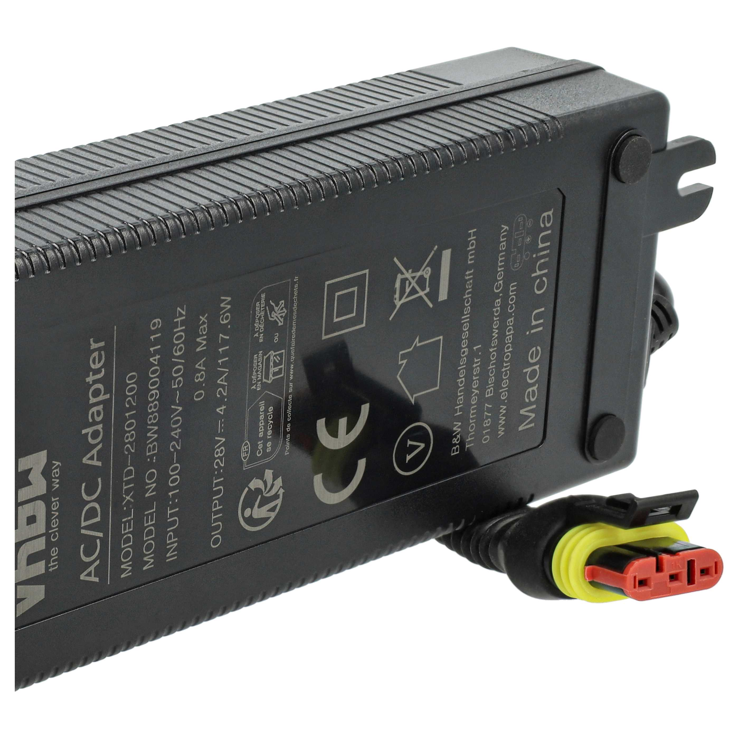 Schwarzer AC/DC-Adapter mit Textetiketten, einem gelb-roten Stecker und strukturierter Oberfläche.