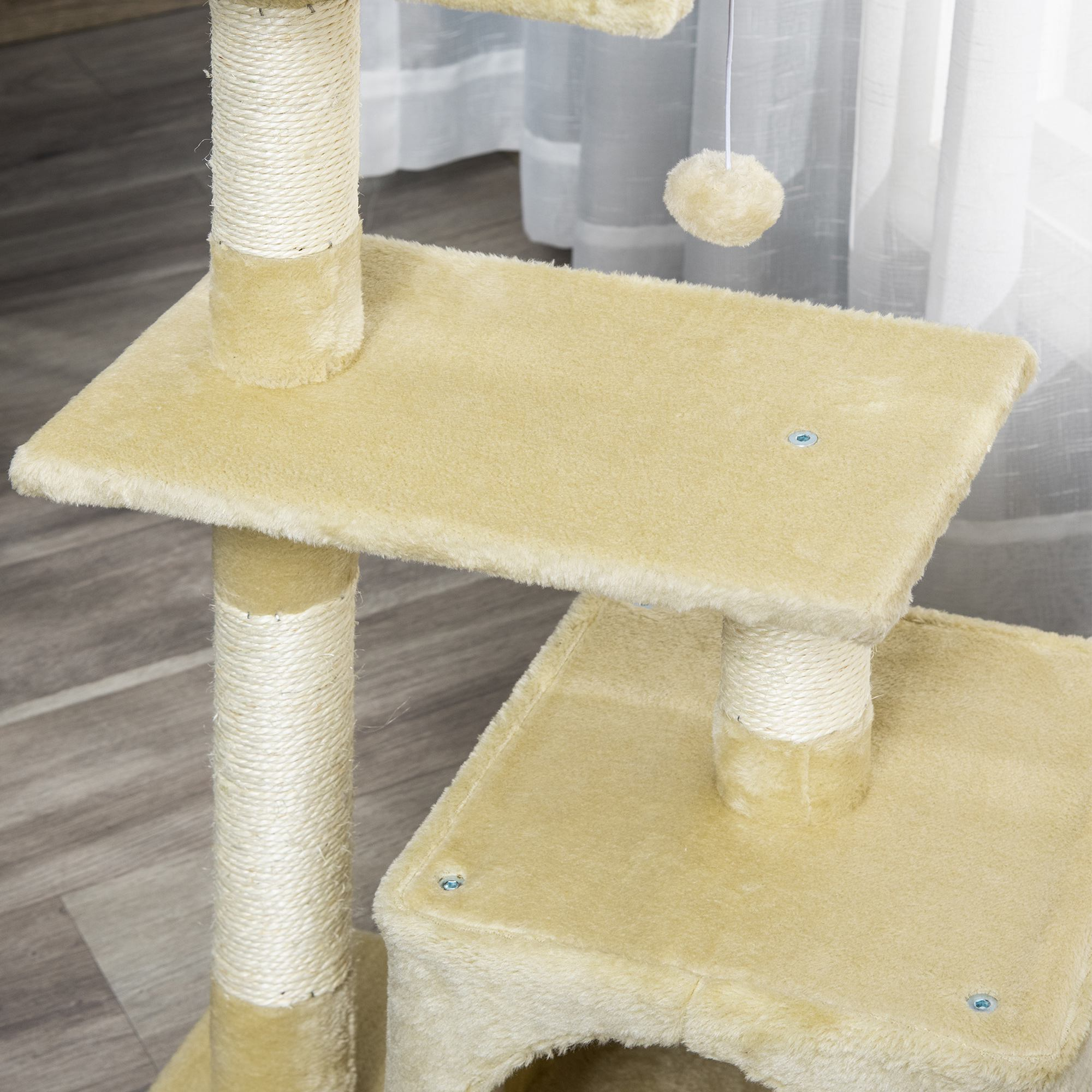 Árbol para gatos beige con múltiples niveles y postes rascadores. Una borla colgante cuelga del nivel superior.