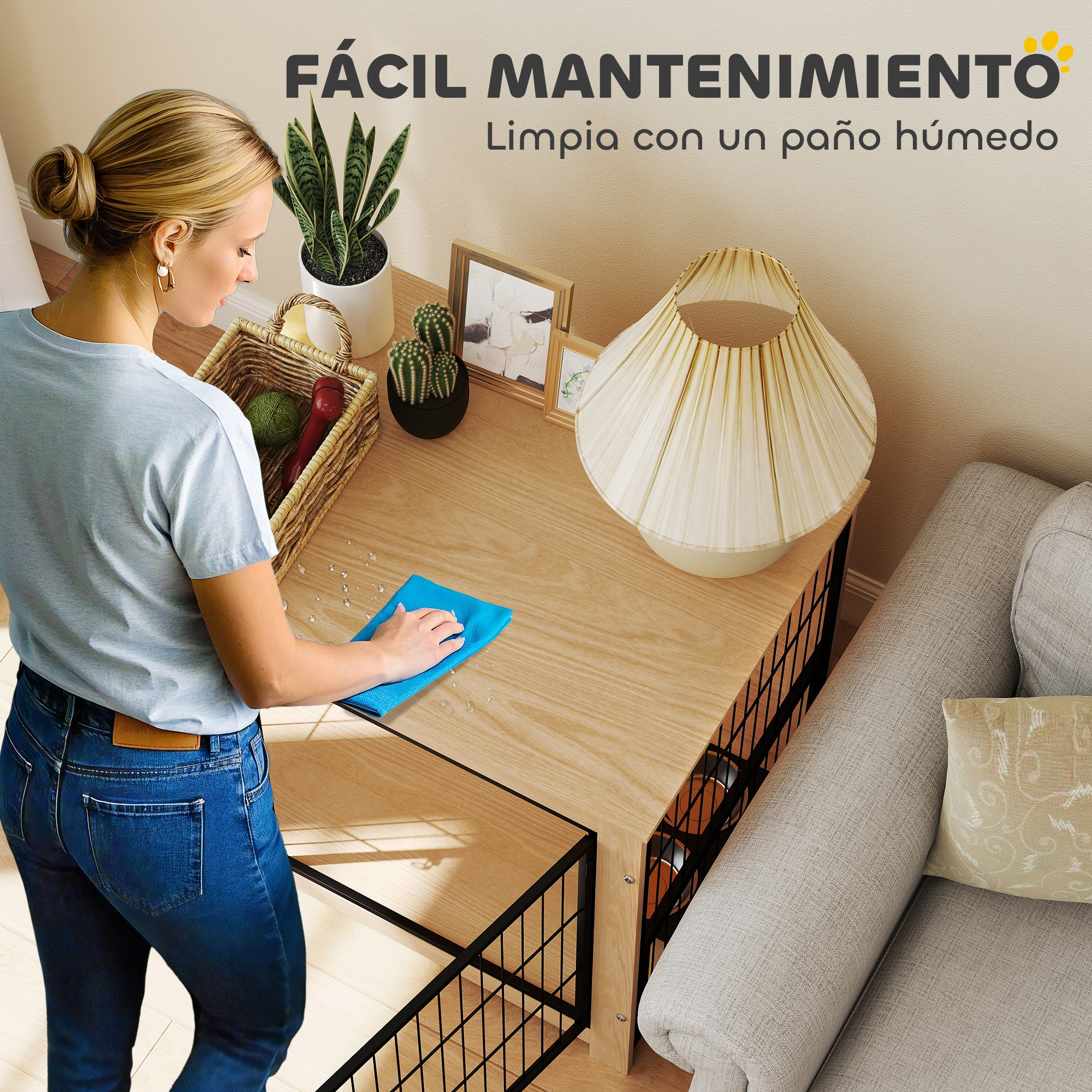 Una mujer limpia una mesa de madera con un paño azul. La mesa tiene plantas y una lámpara. Un sofá está en el fondo.